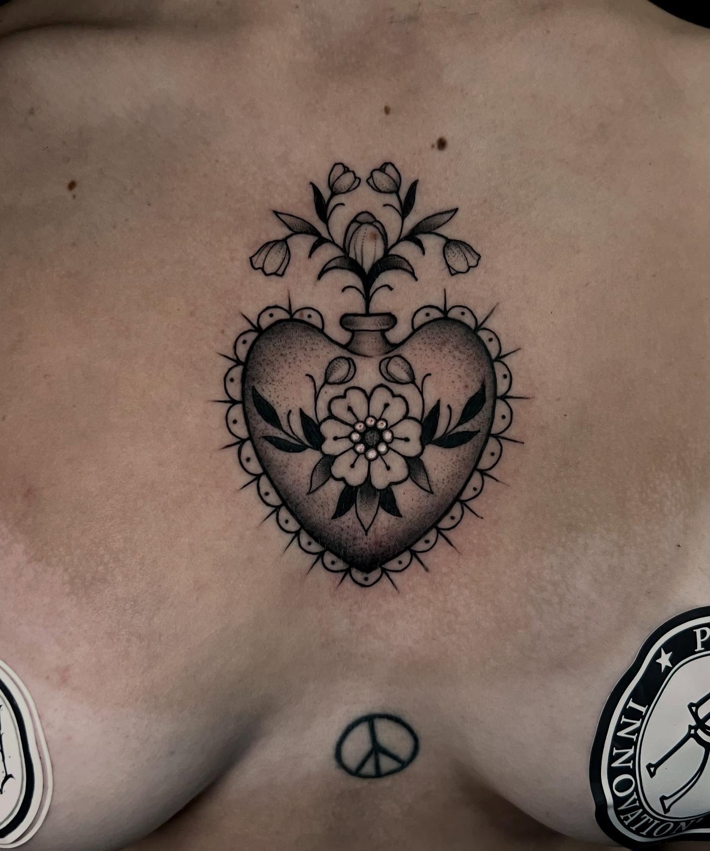 Heart with floral decoration black and grey tattoo on the chest by 𝙻𝚒𝚊 𝙹𝚎𝚙𝚙𝚎𝚜𝚎𝚗