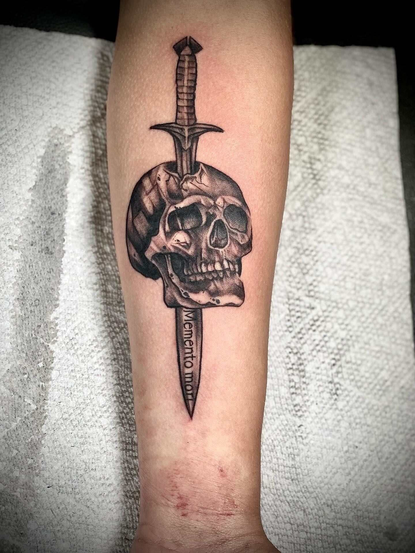 Skull and dagger realism tattoo on the forearm by Chris Klee