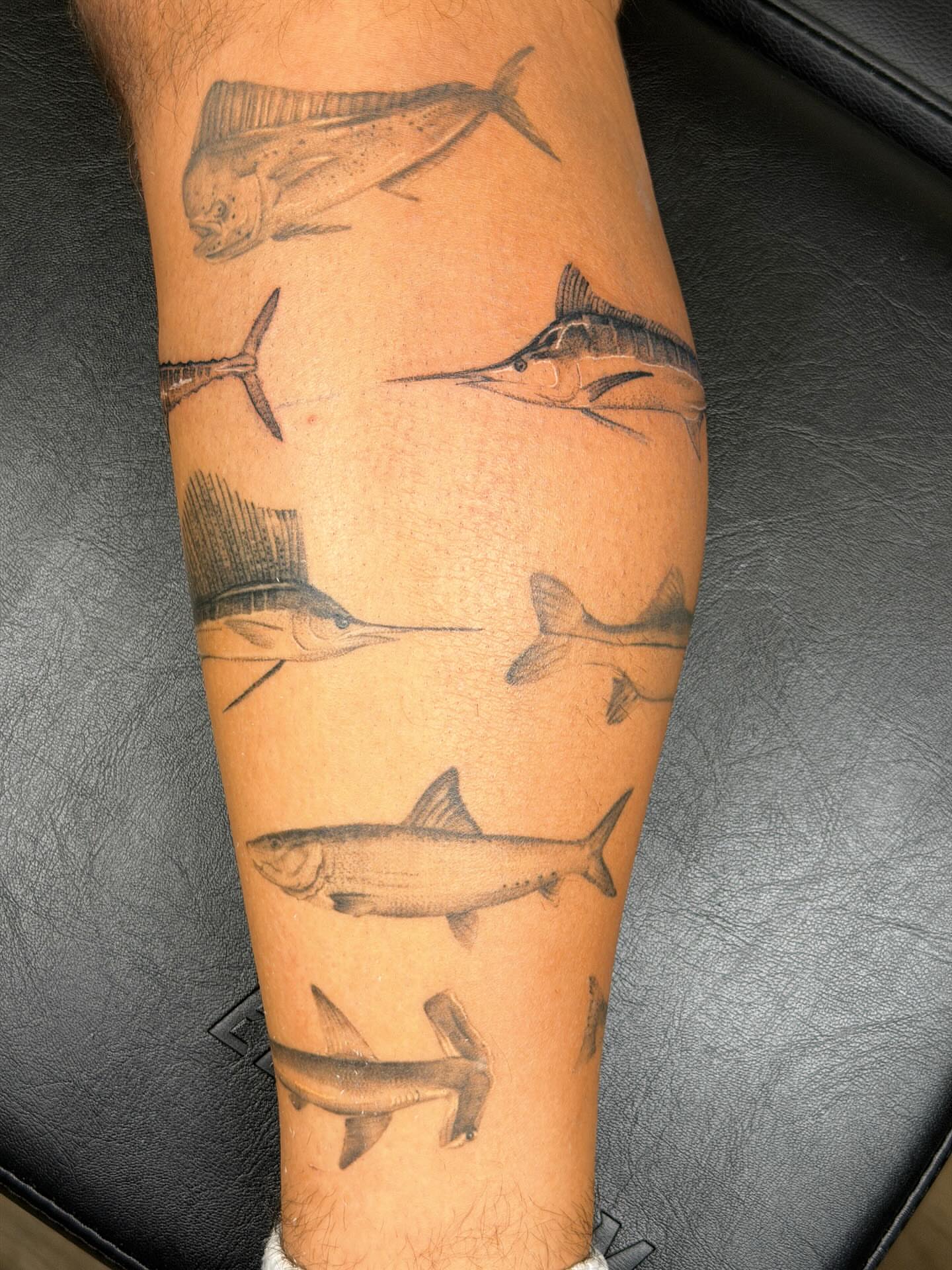Fishes black and grey tattoo on the forearm by Nate Weaver