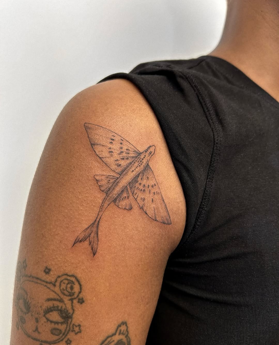 Flying fish fine line tattoo on the shoulder by Helly March