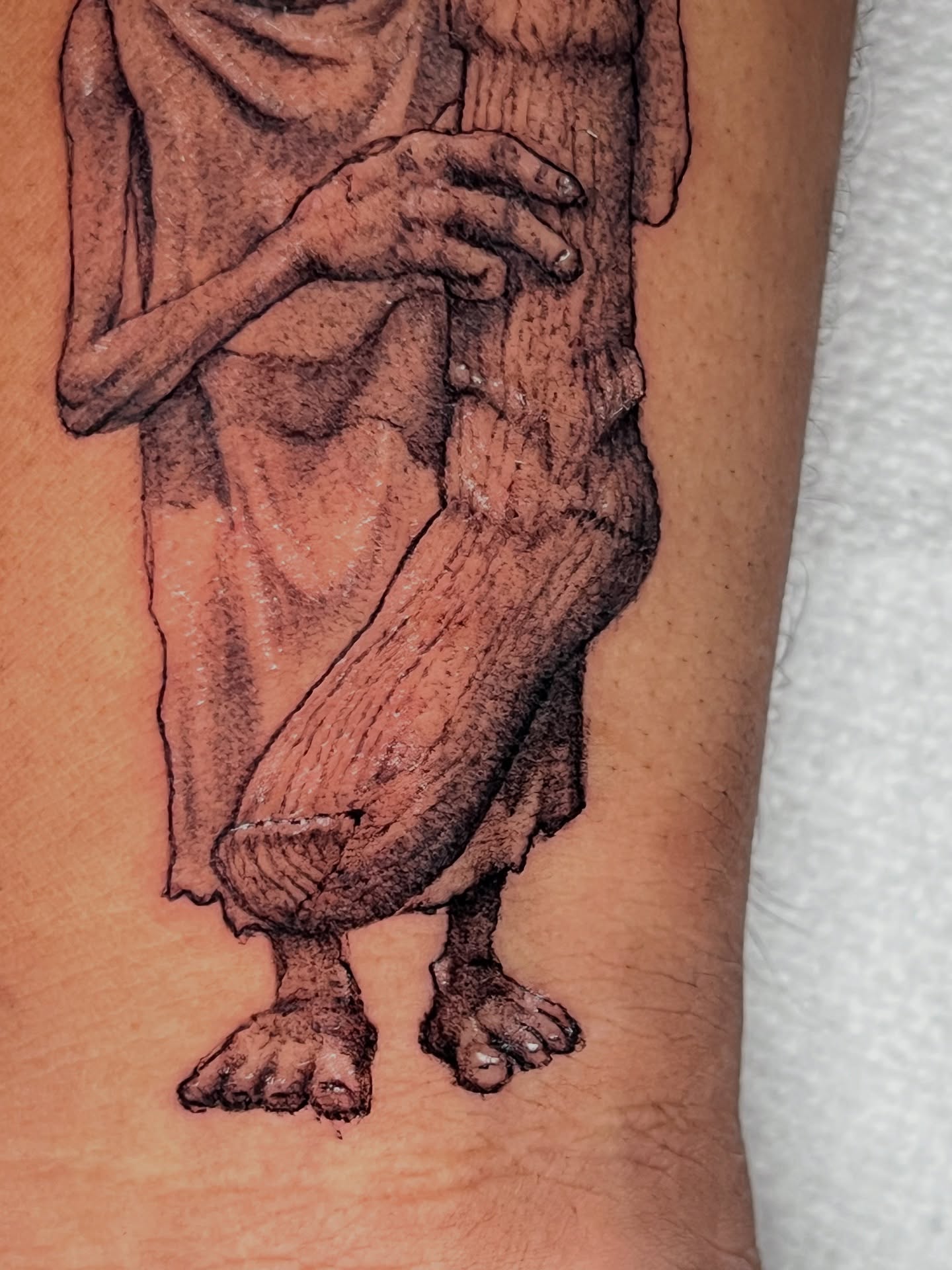 Statue-like figure black and grey tattoo on the forearm by Dotwork