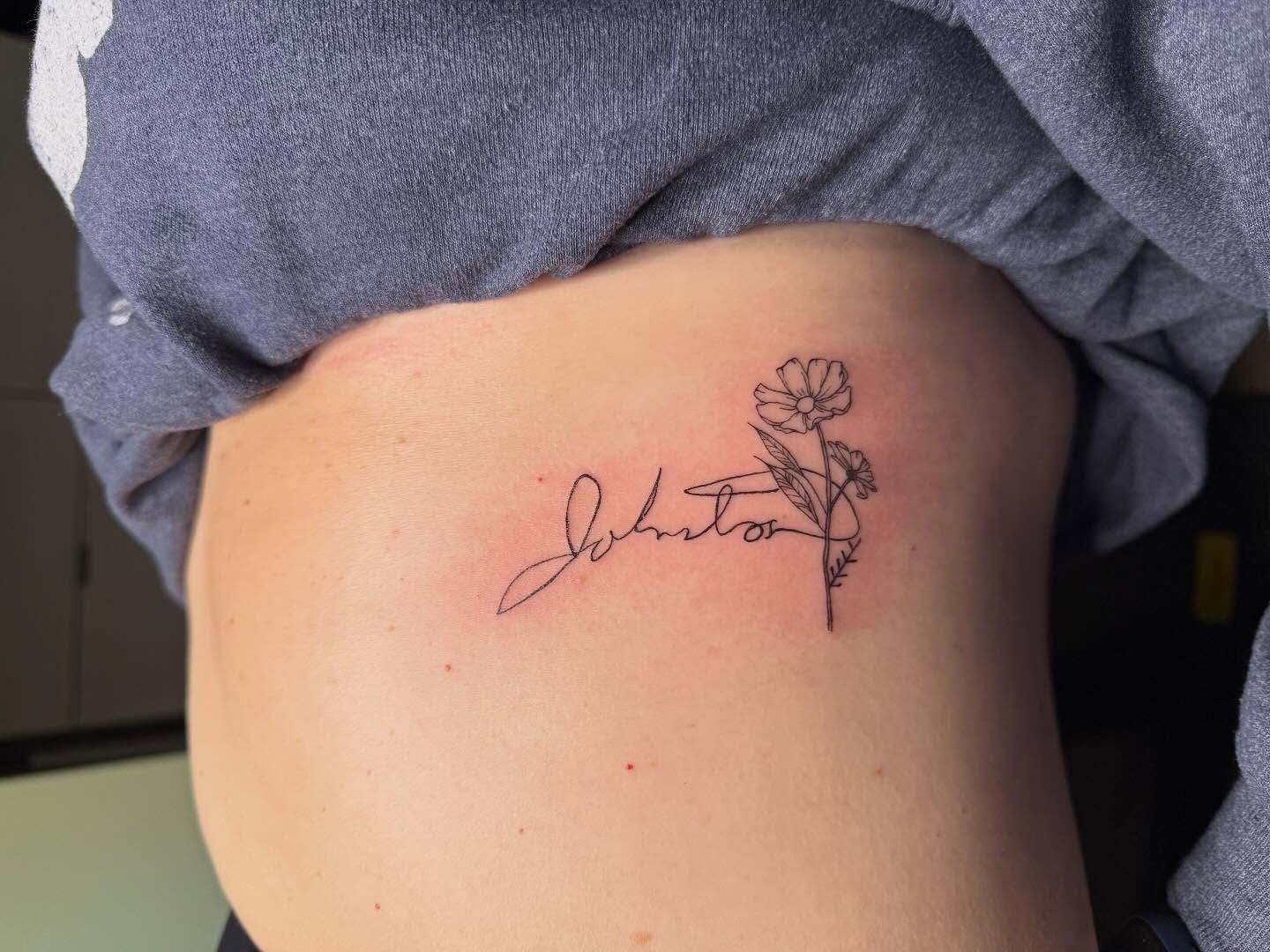 Signature with flower fine line tattoo on the ribs by Fineline Tattoos π€ Hailey L.