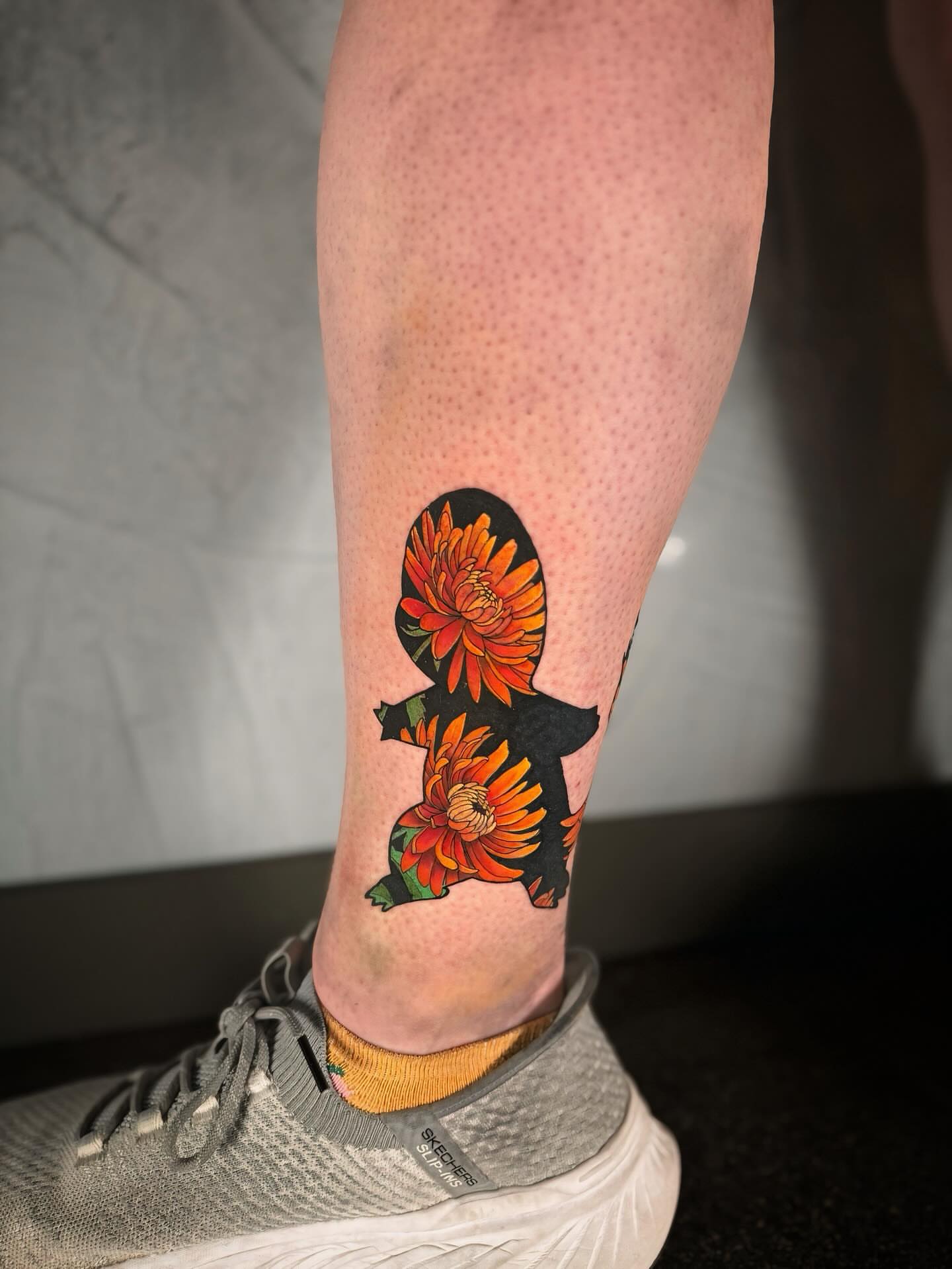 Flower silhouette dotwork tattoo on the calf by Ethan Lund