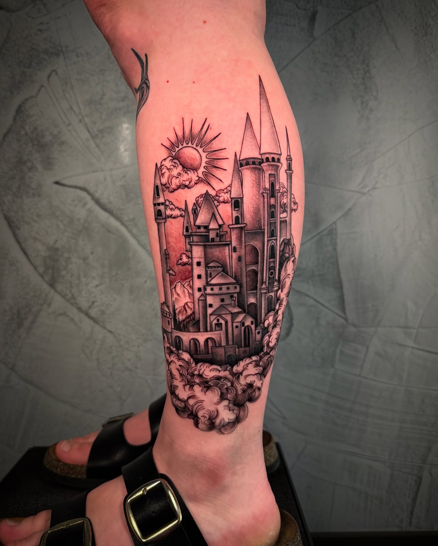Castle black and grey tattoo on the calf by Ethan Lund