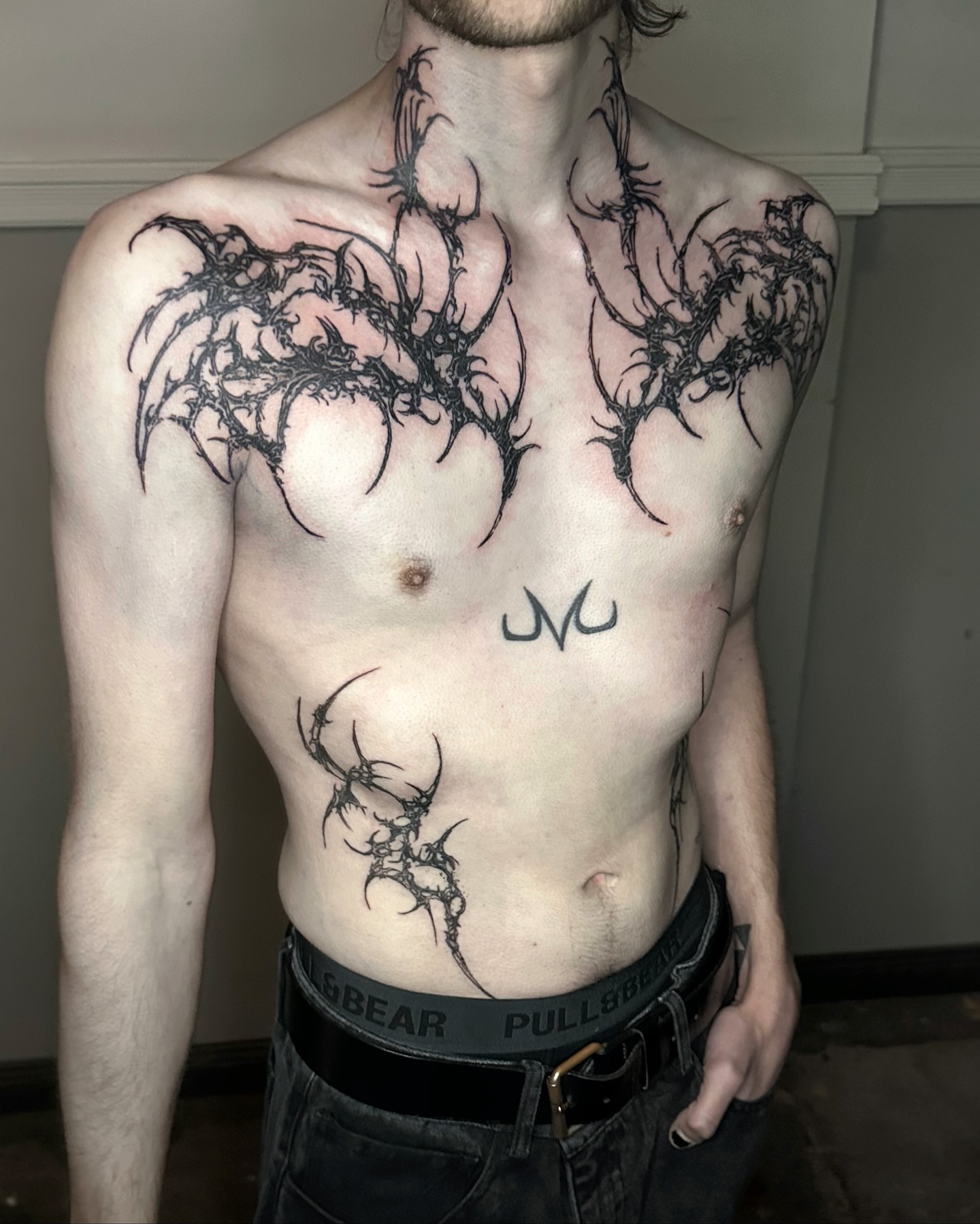Thorn-like patterns black and grey tattoo on the chest by Gun