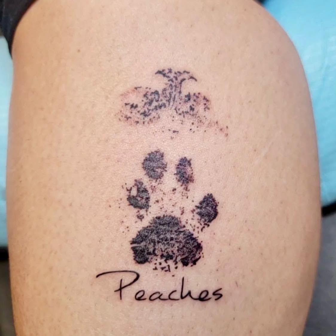 Paw print dotwork tattoo on the upper arm by Brie Marie