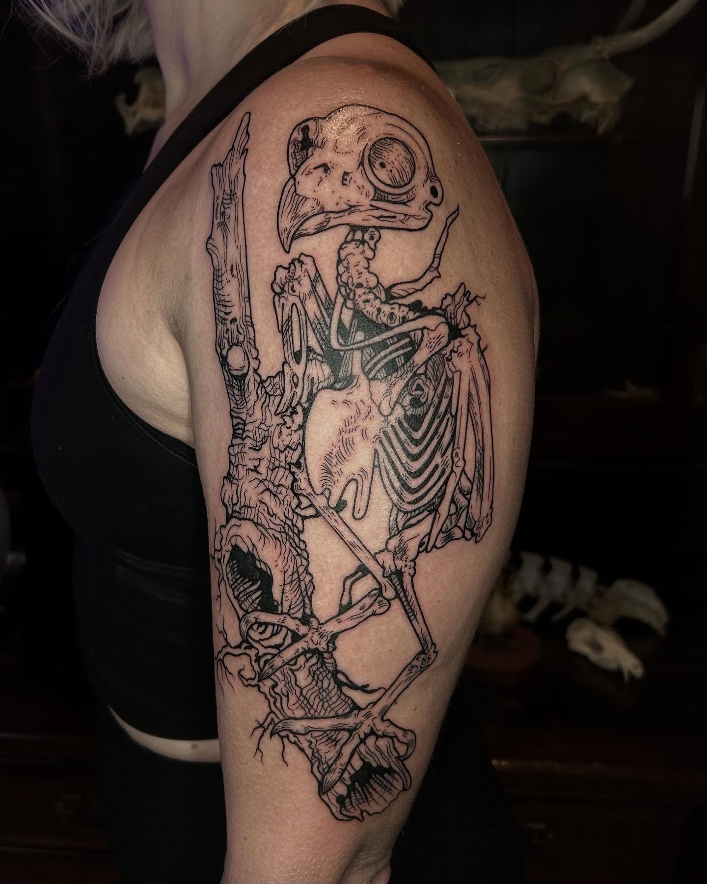Skeleton with bird head realism tattoo on the shoulder by Deanna Louise