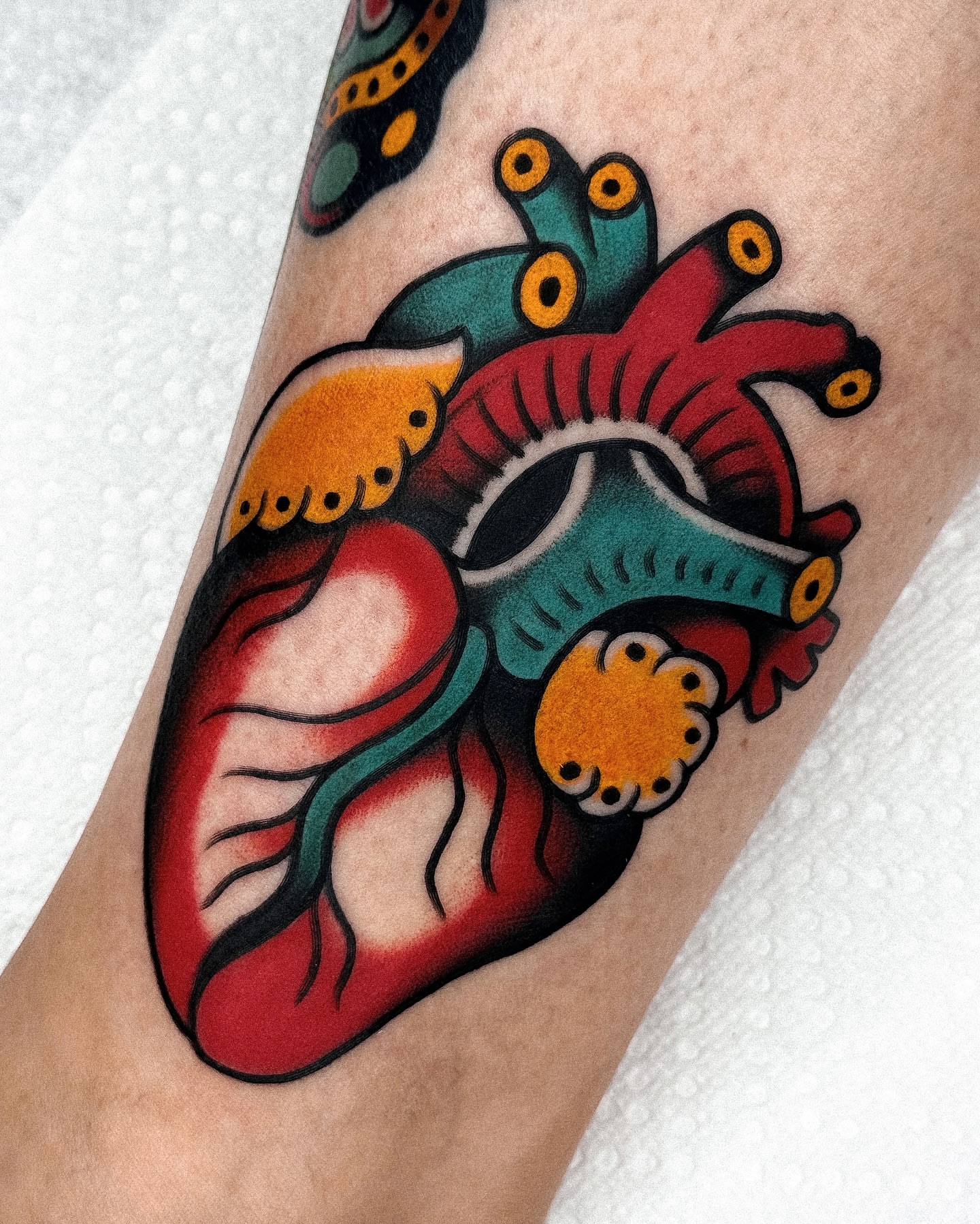 Heart American traditional tattoo on the forearm by Samuel Dickey