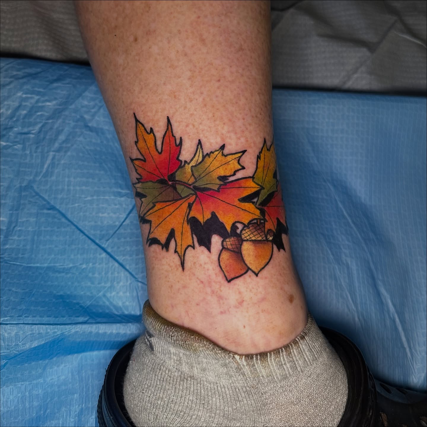 Fall leaves and acorns realism tattoo on the calf by Robert Douglas