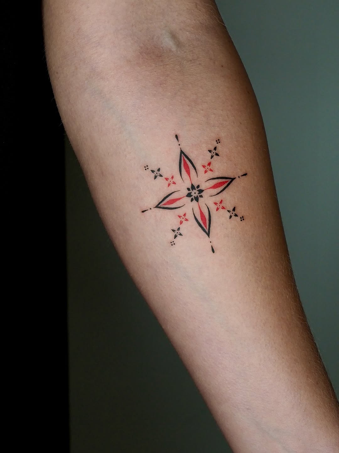 Geometric starburst ornamental tattoo on the forearm by A. Eye Tat