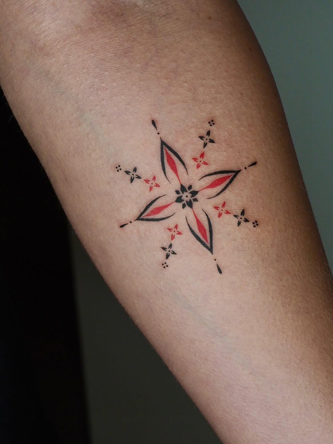 Geometric starburst ornamental tattoo on the forearm by A. Eye Tat