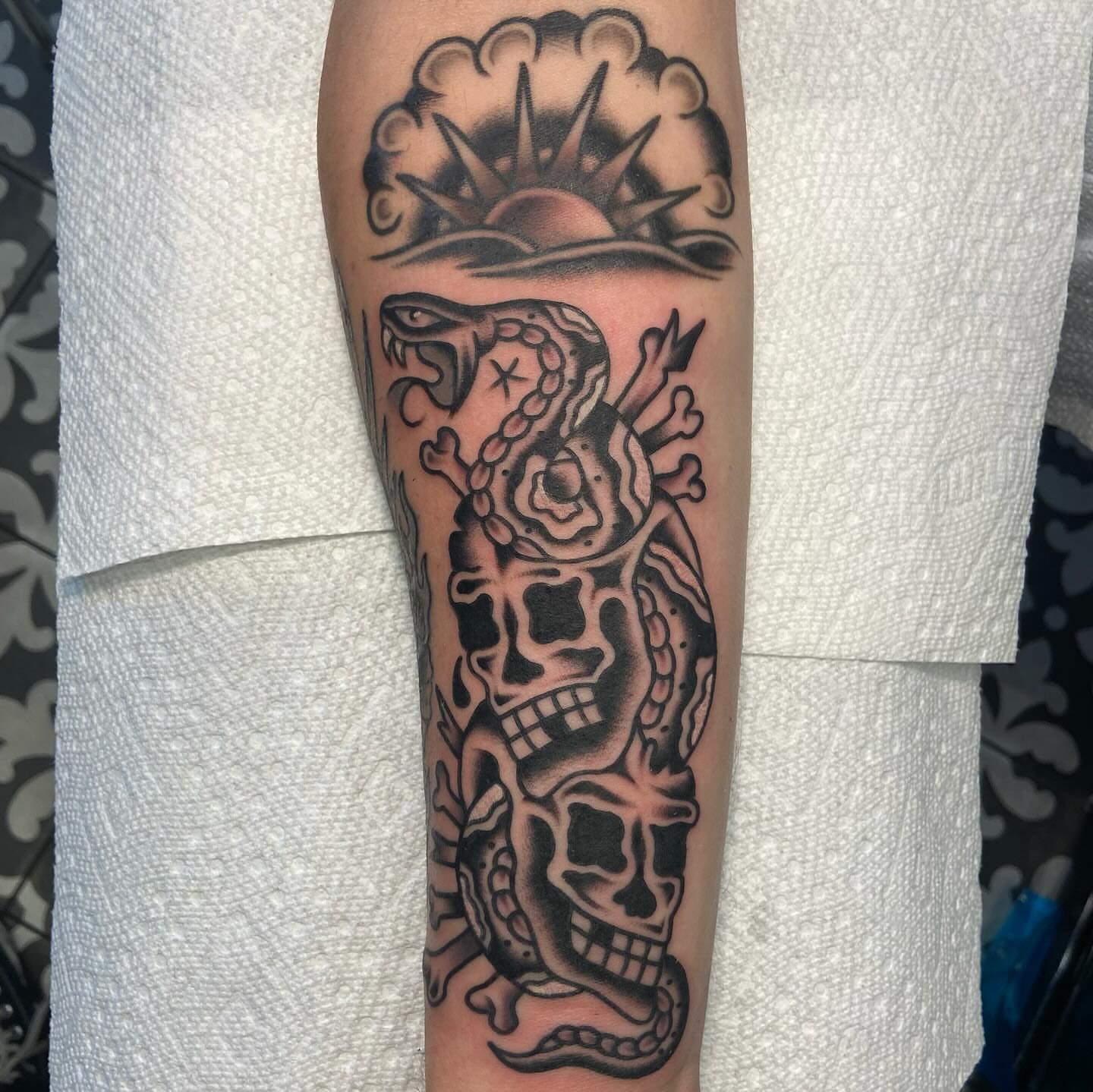 Skulls and snake black and grey tattoo on the forearm by Anthony Jaeger, Seattle, Washington