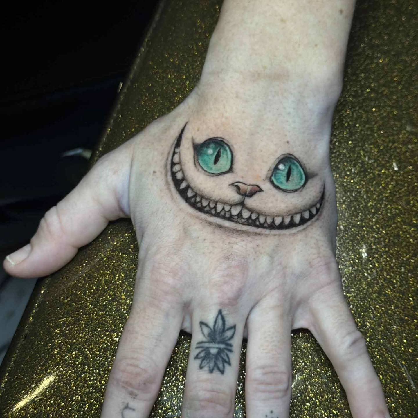 Cheshire cat realism tattoo on the hand by Marquis Neal