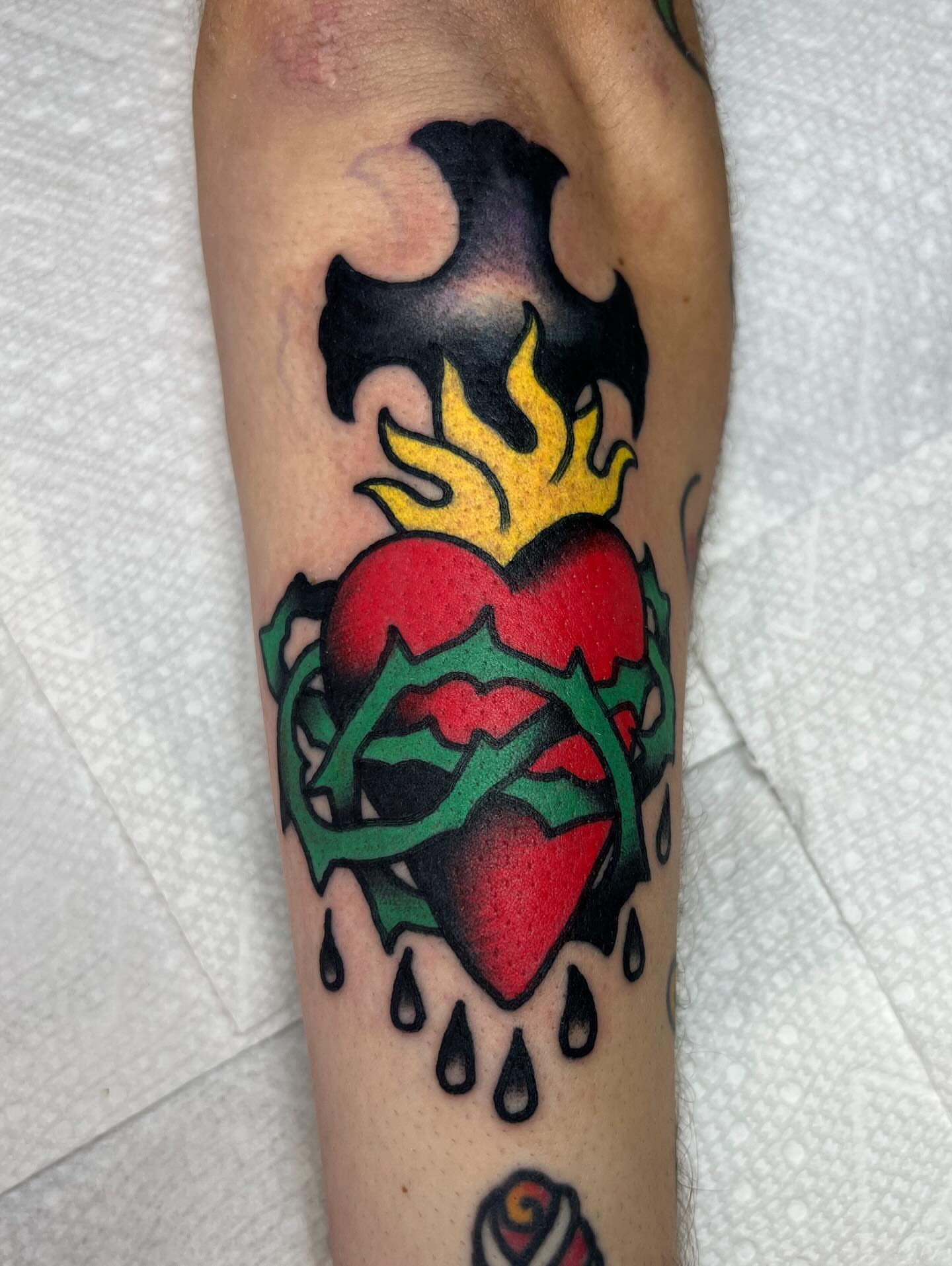 Heart with flames American traditional tattoo on the forearm by Tattoo