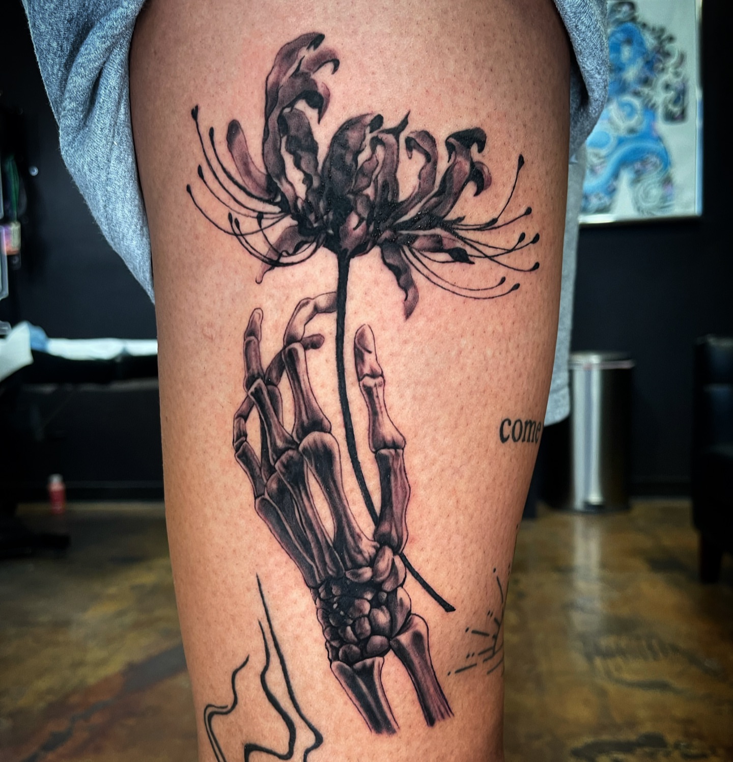 Flower and skeleton hand realism tattoo on the thigh by @tattoos_by_elijah
