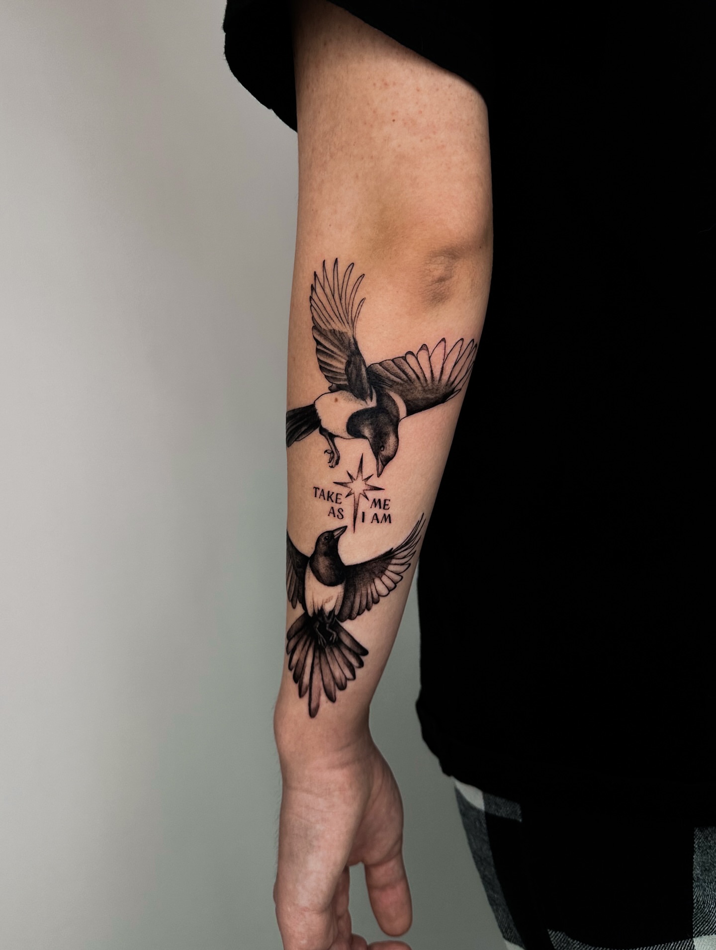 Birds and text black and grey tattoo on the forearm by Lauren