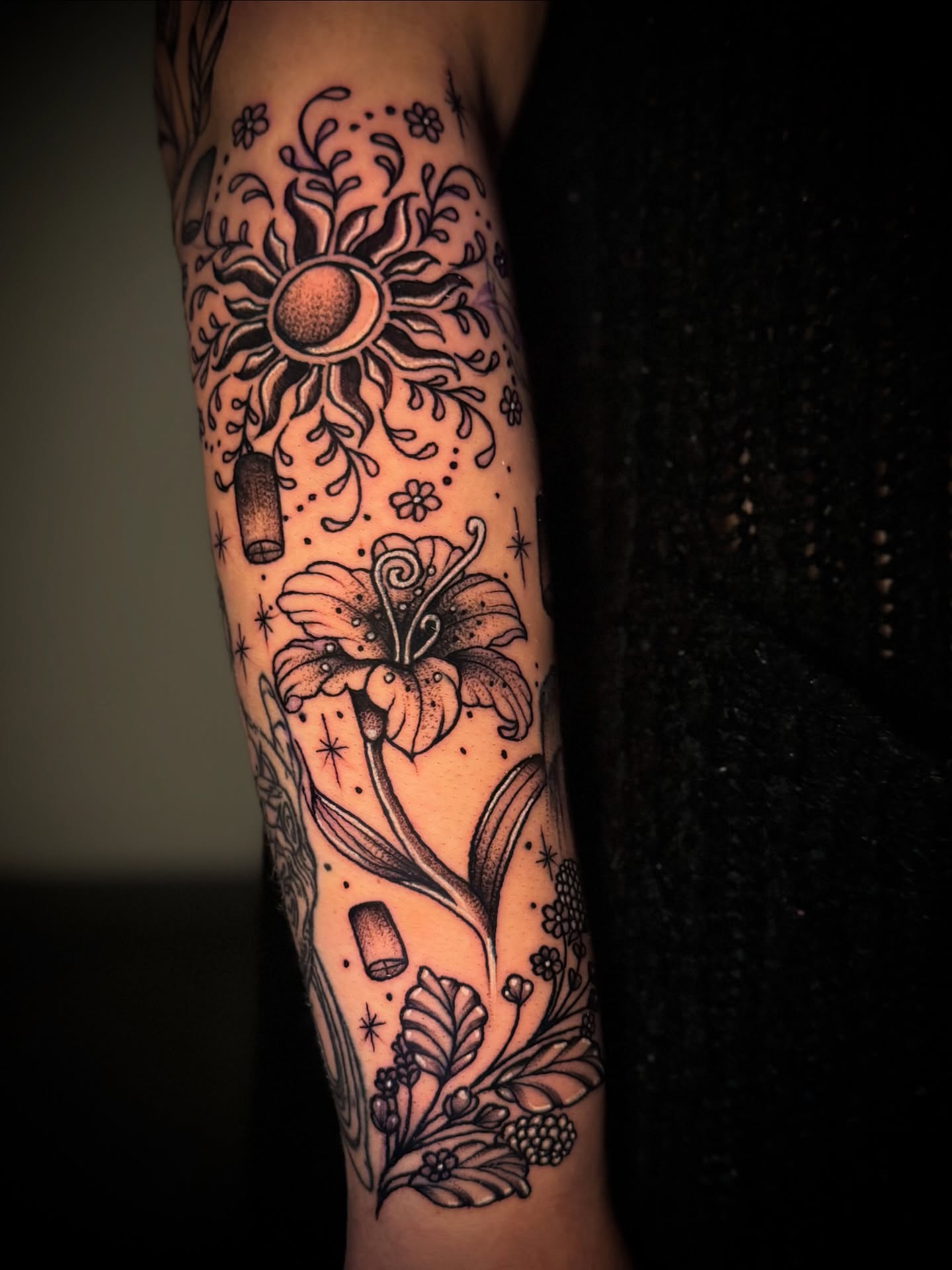 Sun and lily black and grey tattoo on the forearm by Tattoo Artist based in Dallas Tx