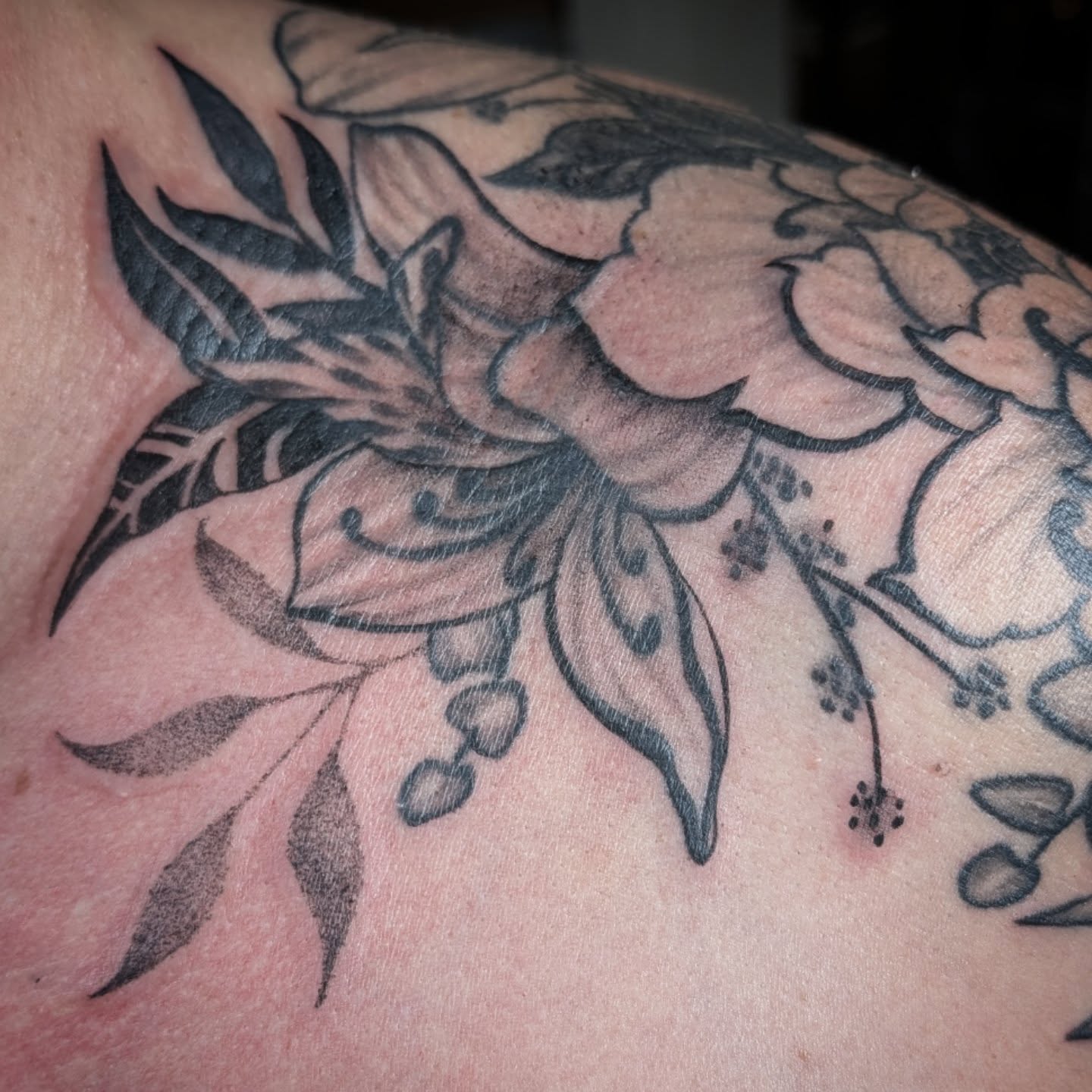 Floral arrangement black and grey tattoo on the shoulder by Michaela May