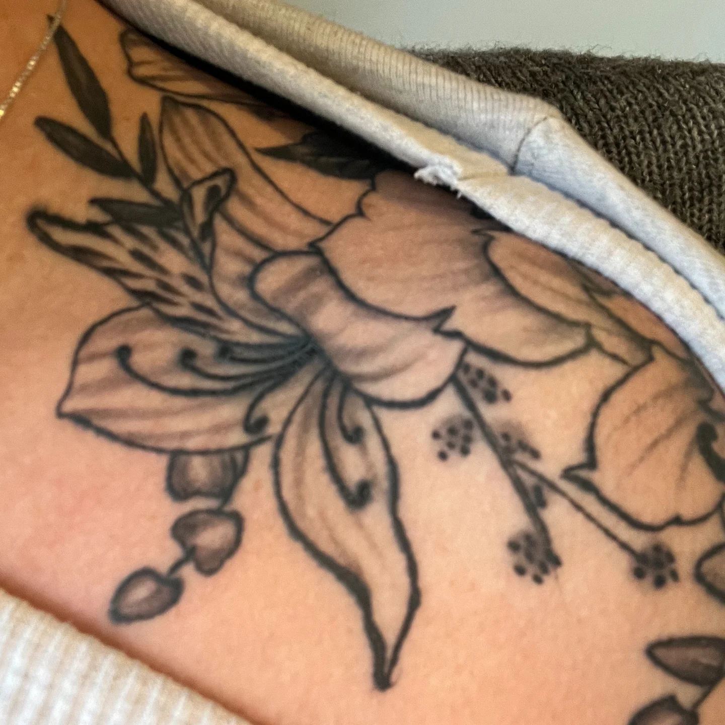 Flower black and grey tattoo on the upper arm by Michaela May