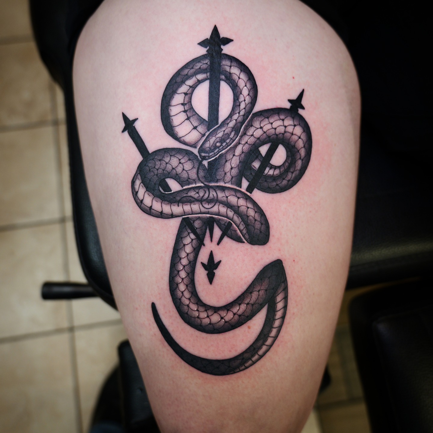 Snake black and grey tattoo on the thigh by bobby allensworth