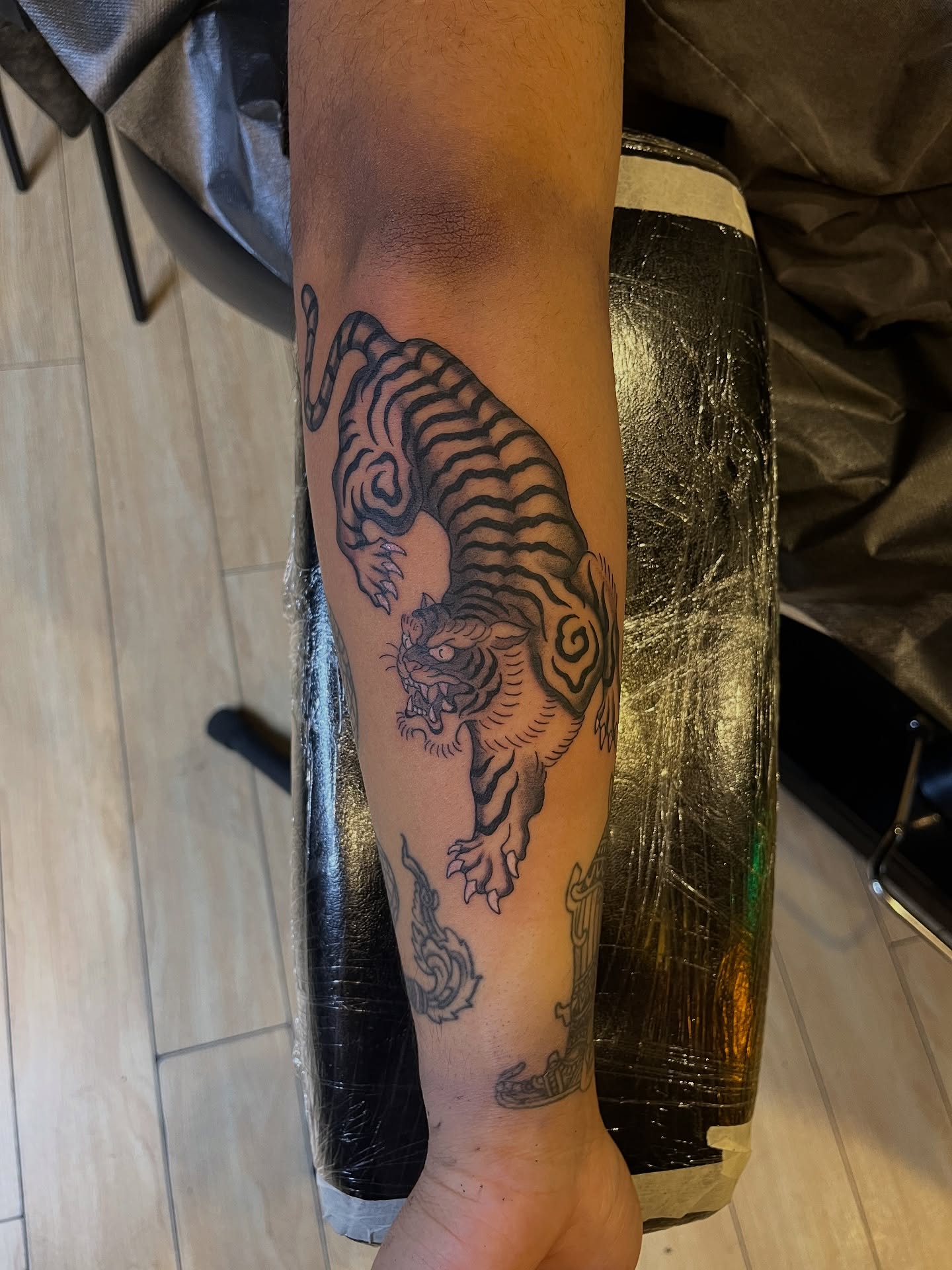 Tiger black and grey tattoo on the forearm by Winston Thai