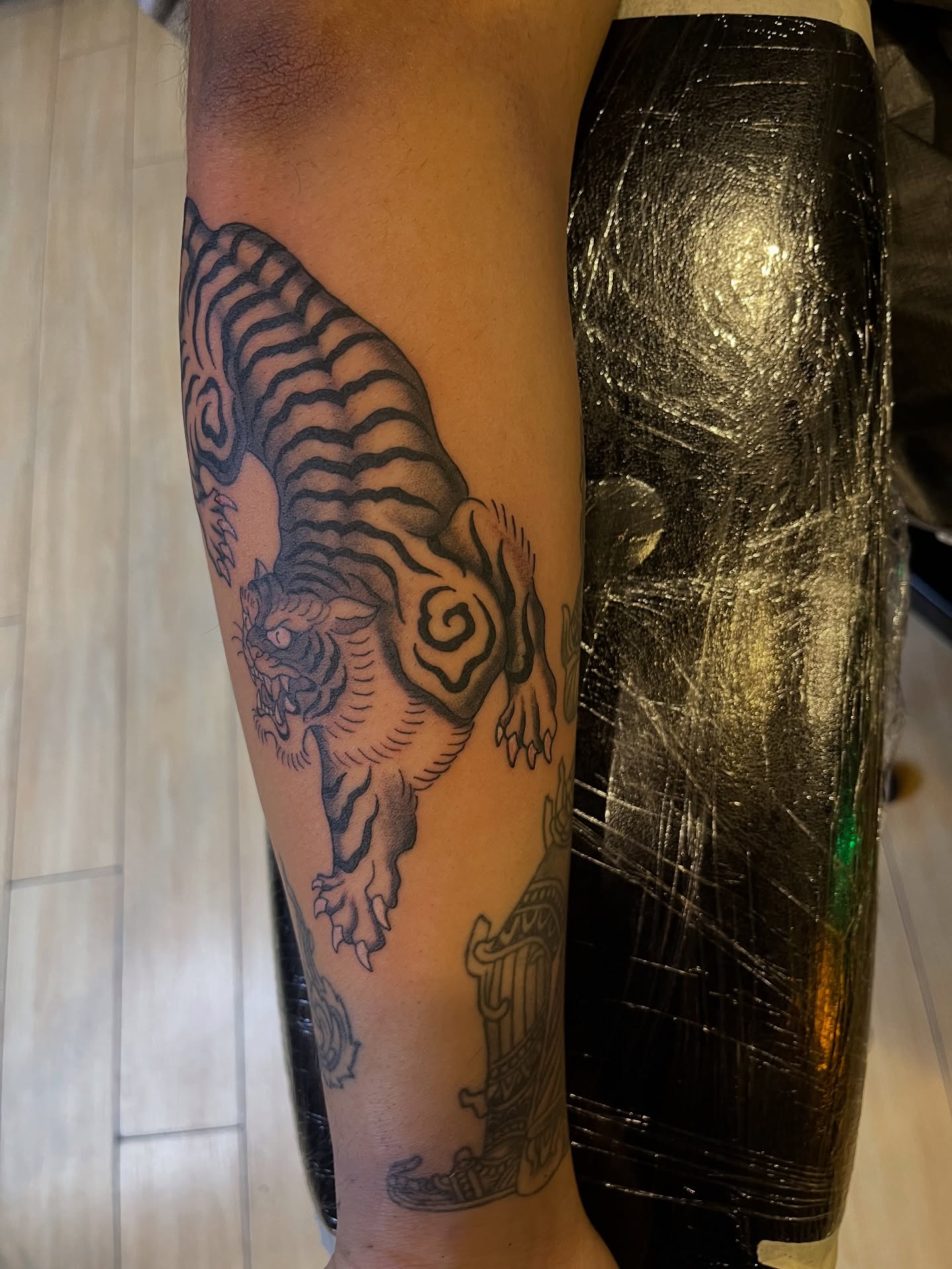 Tiger black and grey tattoo on the forearm by Winston Thai