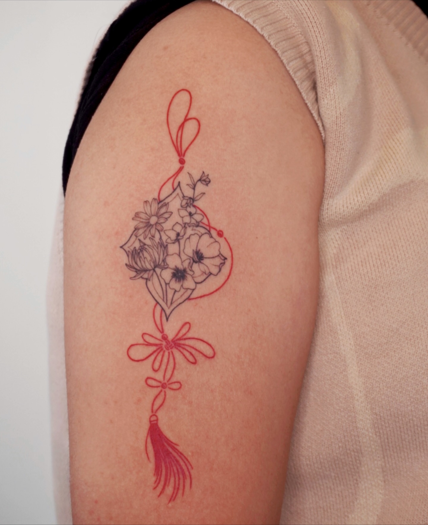 Floral arrangement fine line tattoo on the upper arm by Sun Child Tattoo 🌻