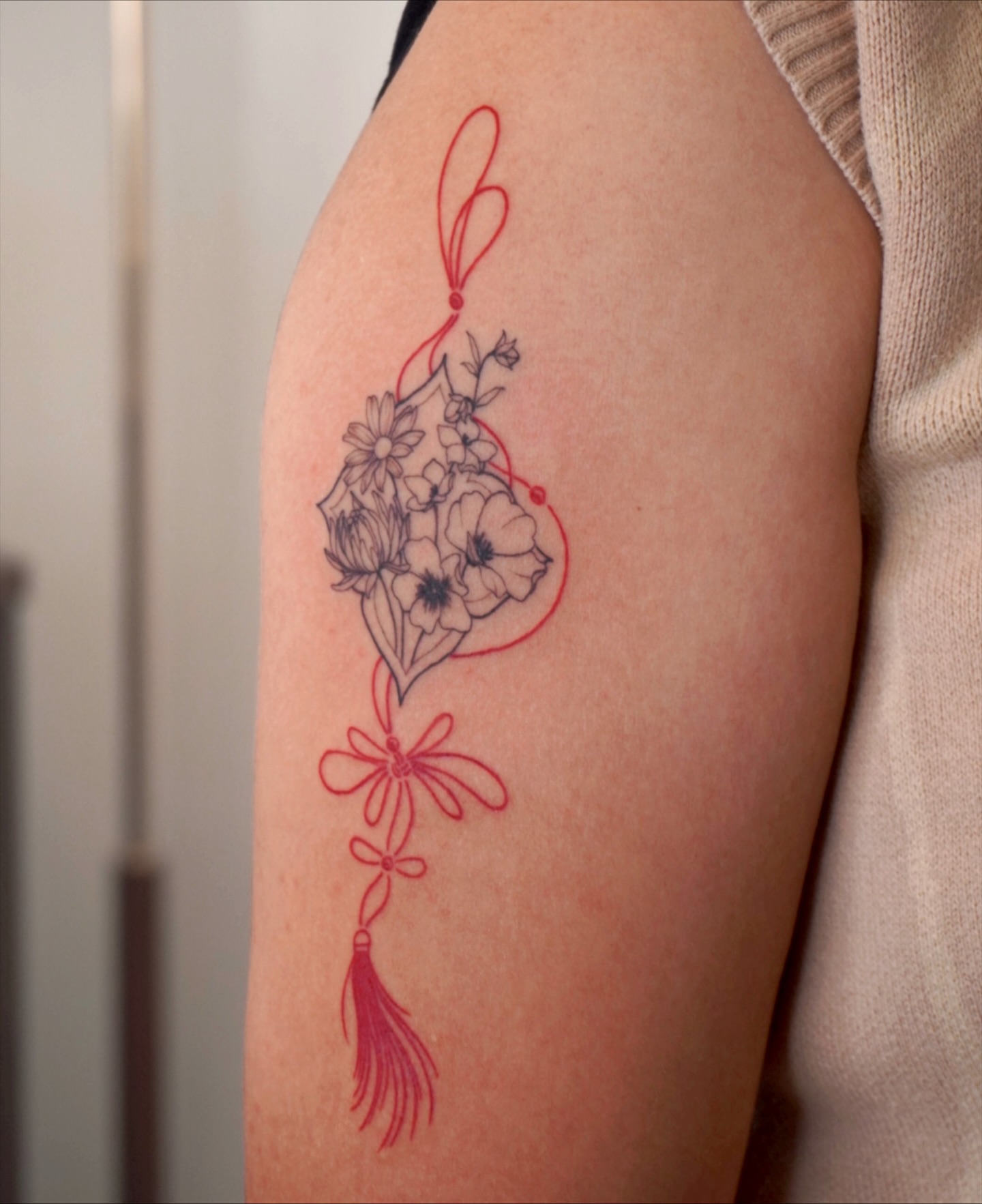 Floral arrangement fine line tattoo on the upper arm by Sun Child Tattoo 🌻