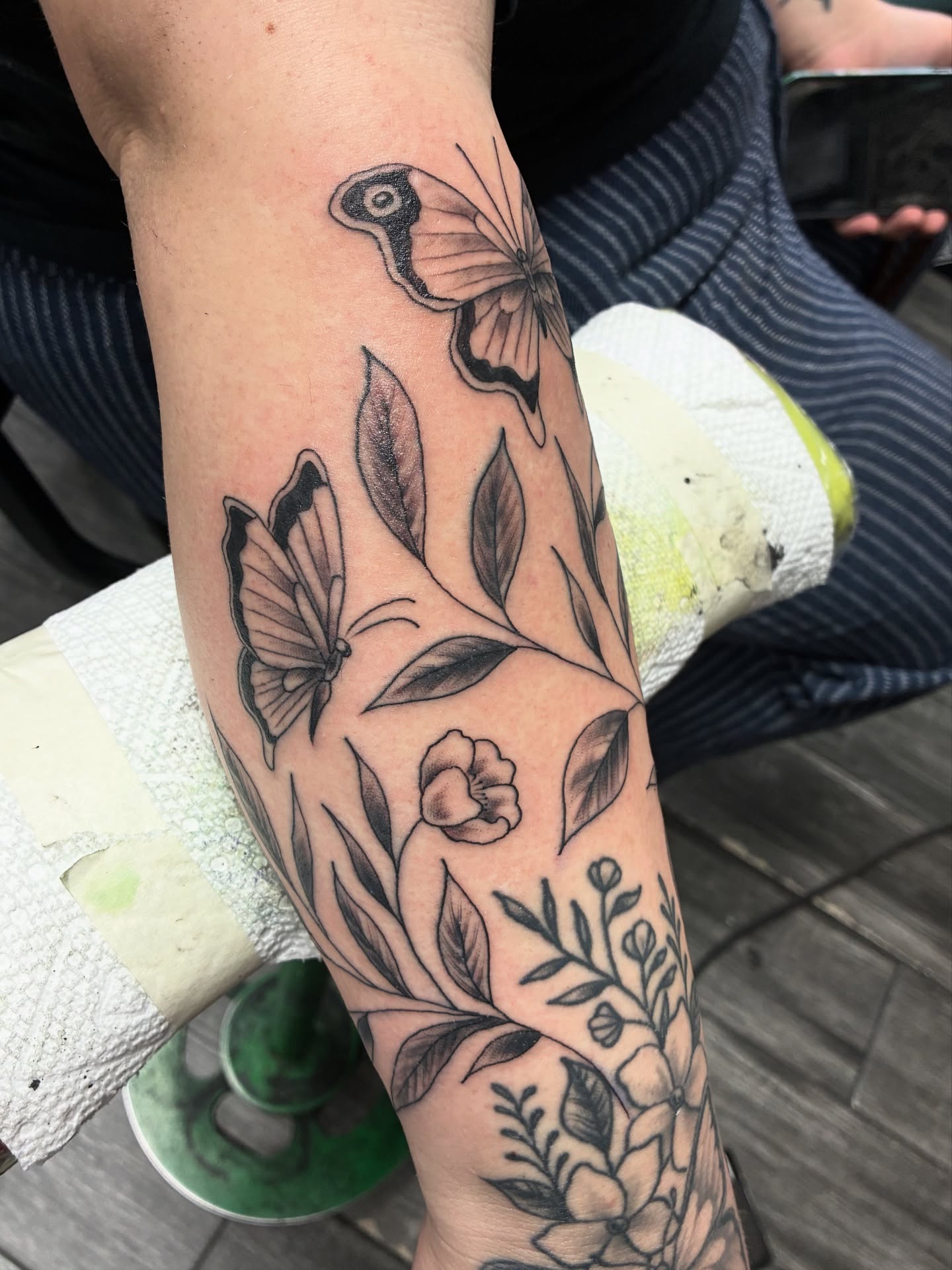 Butterfly and floral realism tattoo on the forearm by Kennedy Cole