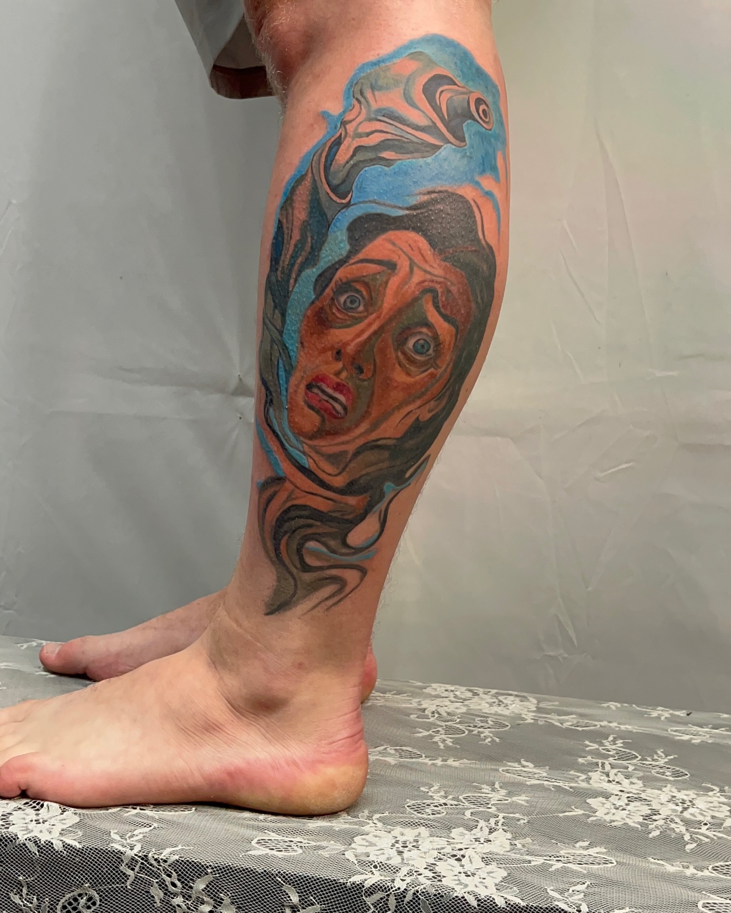 Woman's face realism tattoo on the calf by Ryan Hindenach