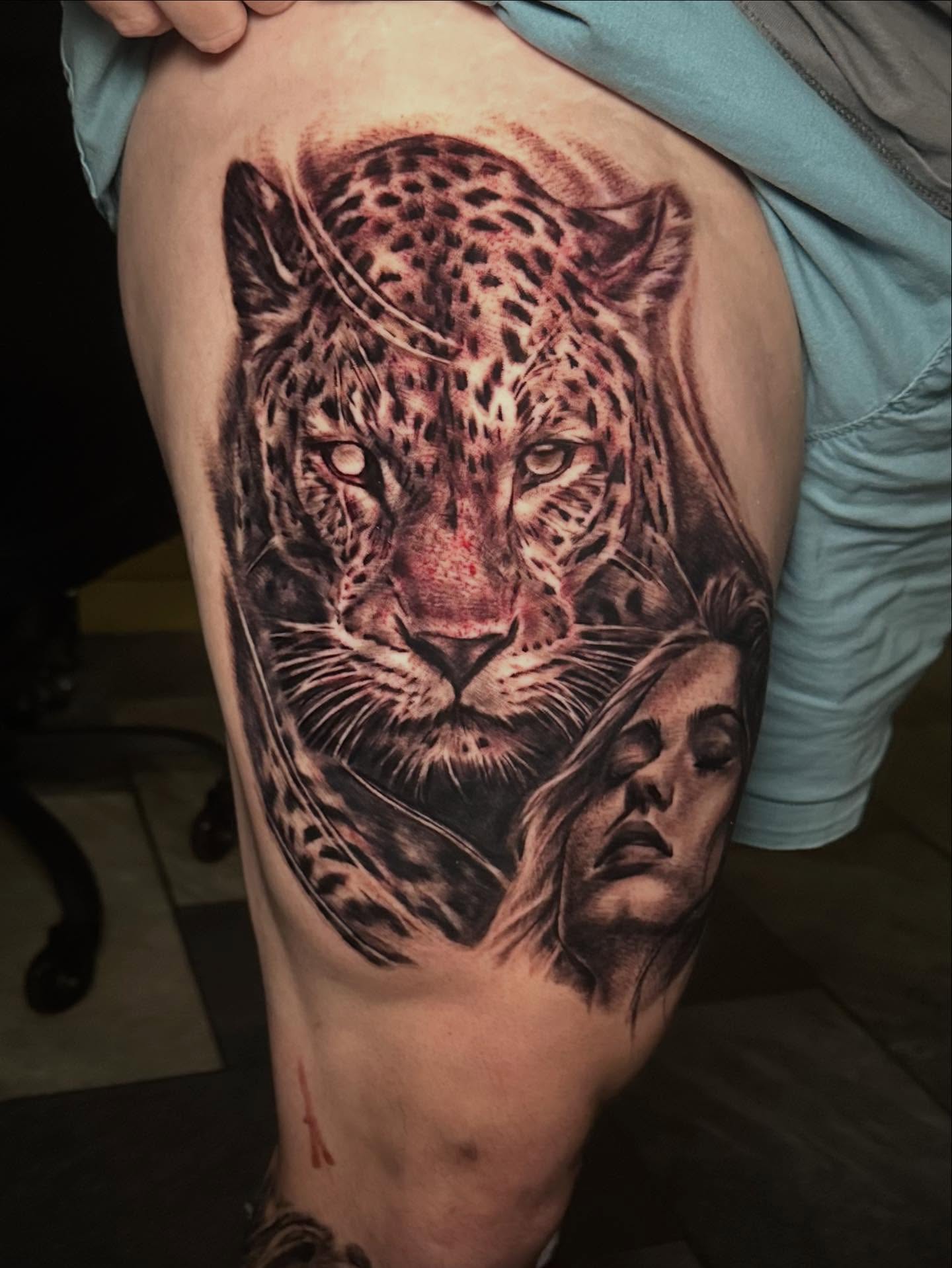 Leopard and woman realism tattoo on the thigh by Comfy Chris Fettig