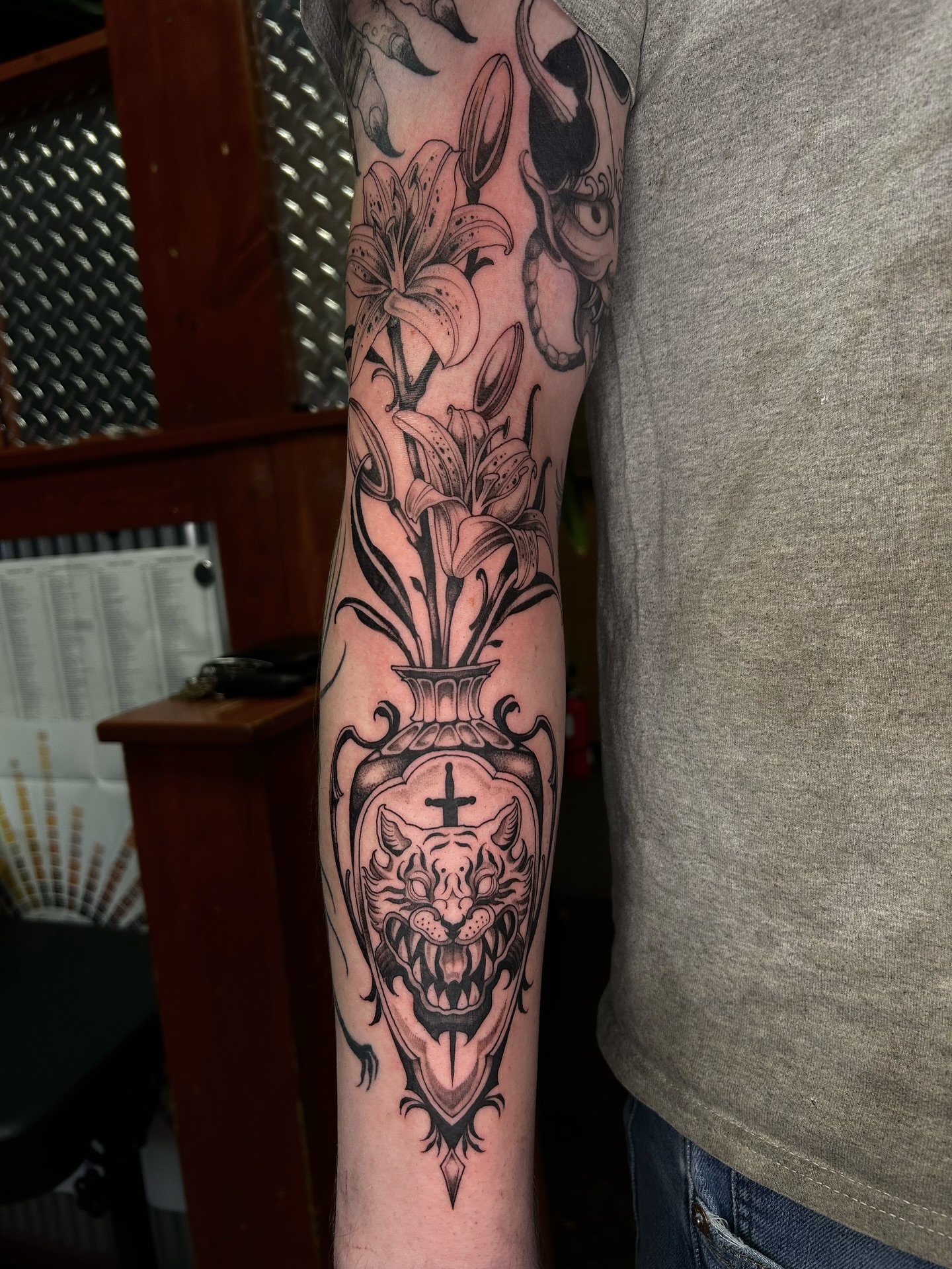 Lilies and tiger realism tattoo on the forearm by Magnus