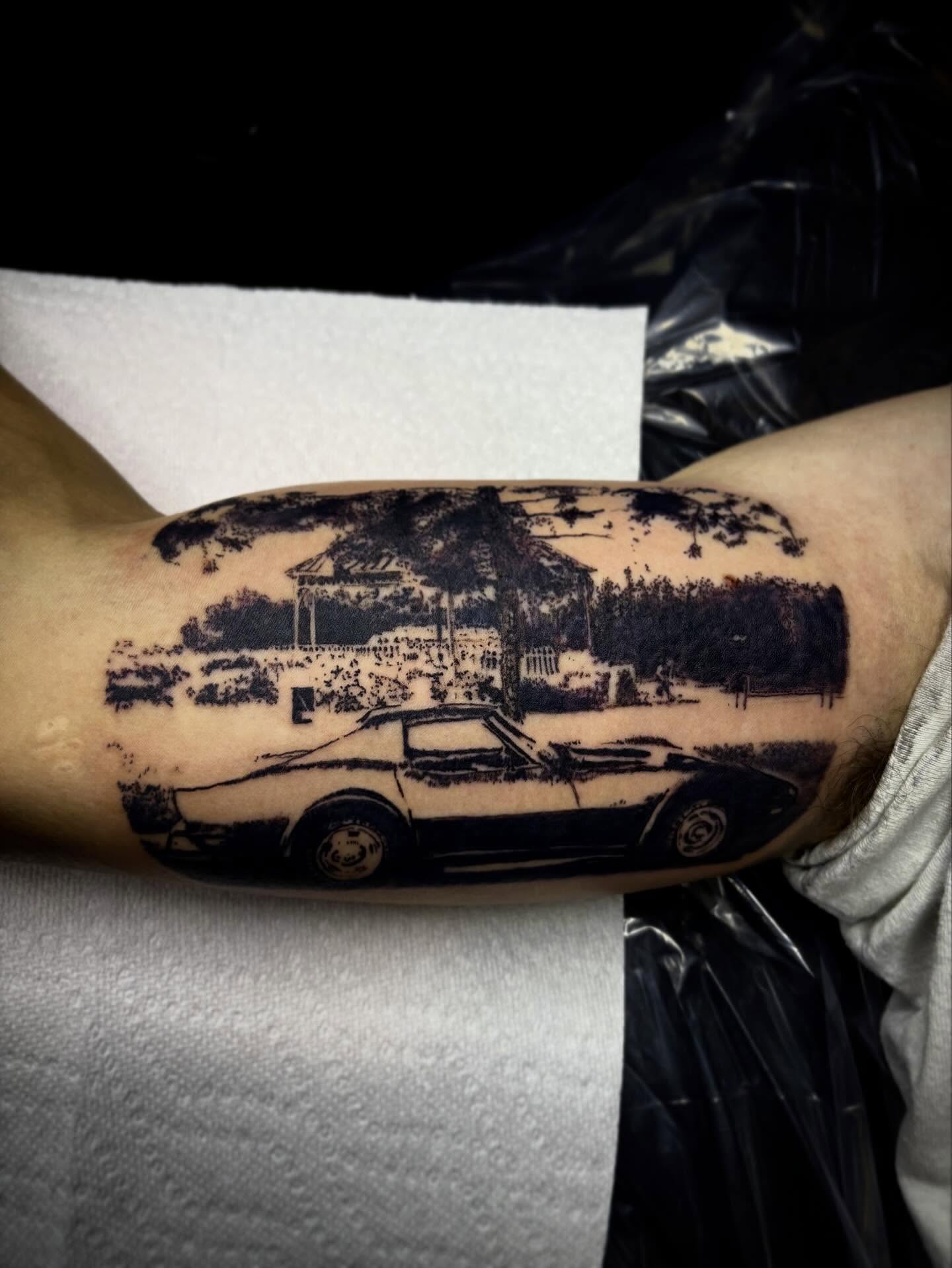 Car and landscape black and grey tattoo on the forearm by Haley Byers