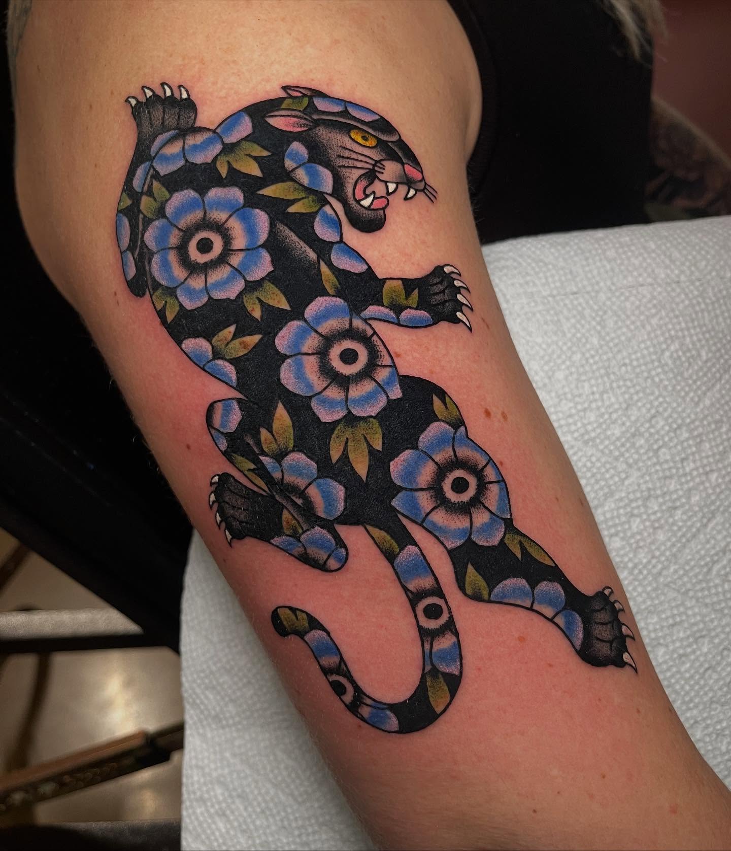 Panther with floral pattern American traditional tattoo on the forearm by Marqui Watling