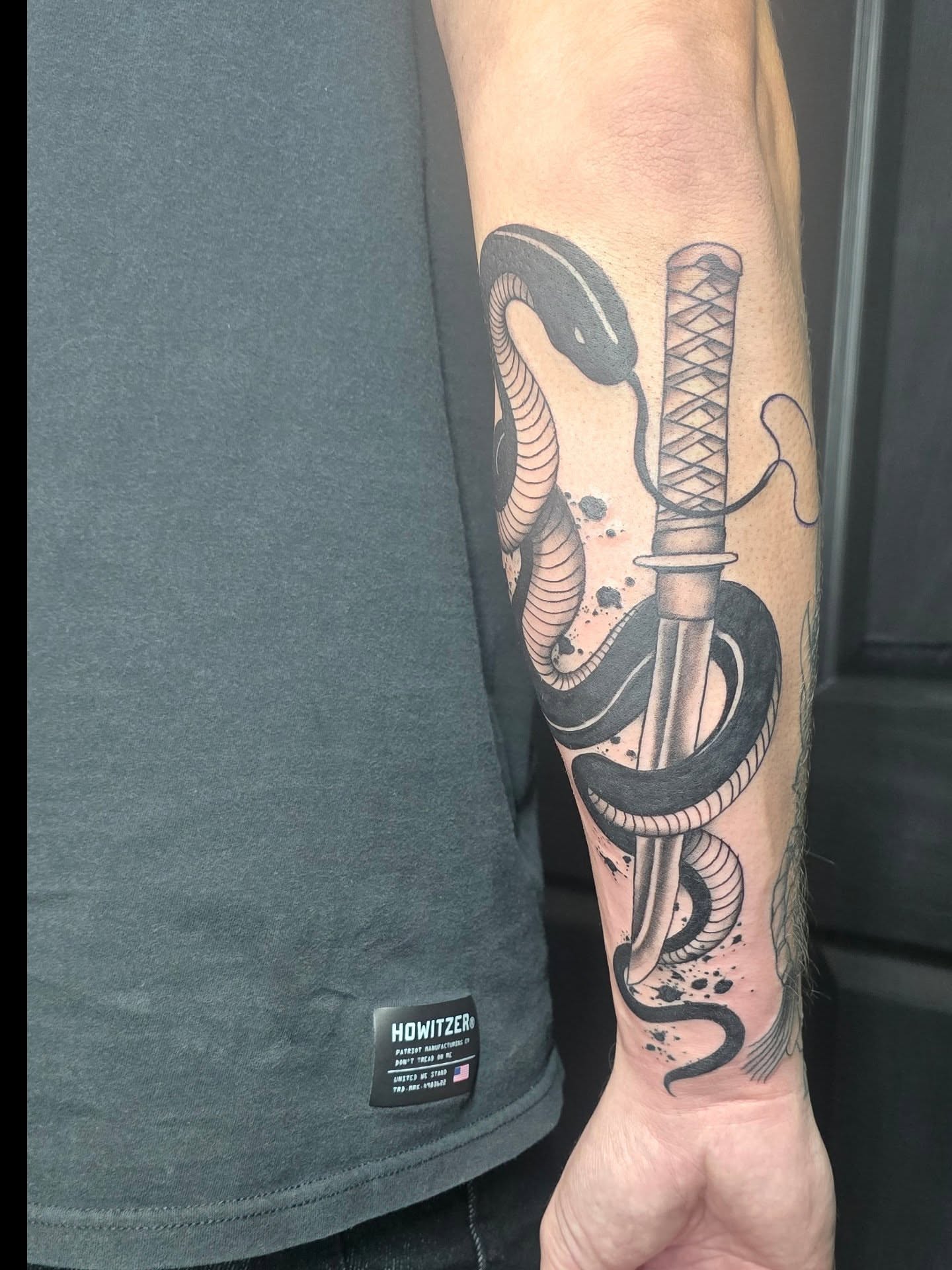 Snake and katana black and grey tattoo on the forearm by Trinity