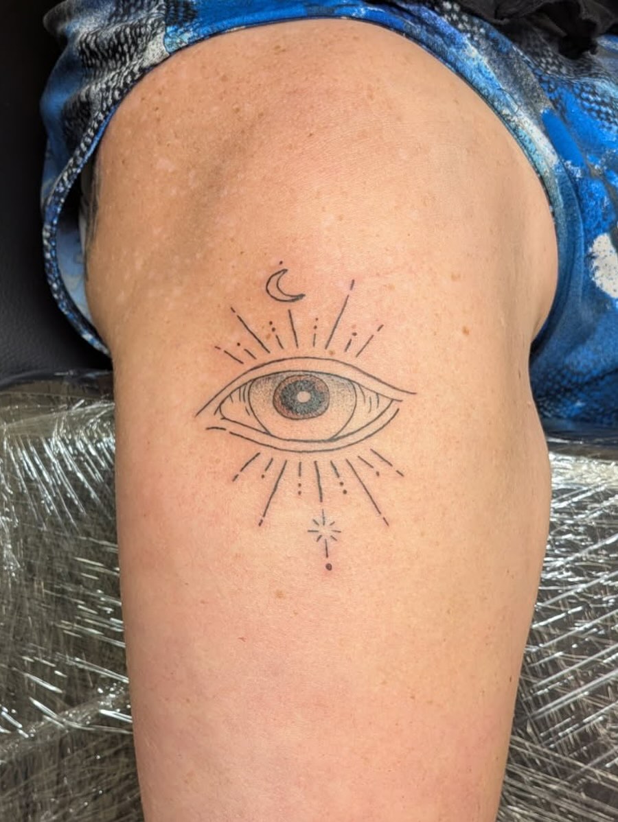 Eye with sunburst geometric tattoo on the thigh by Kam