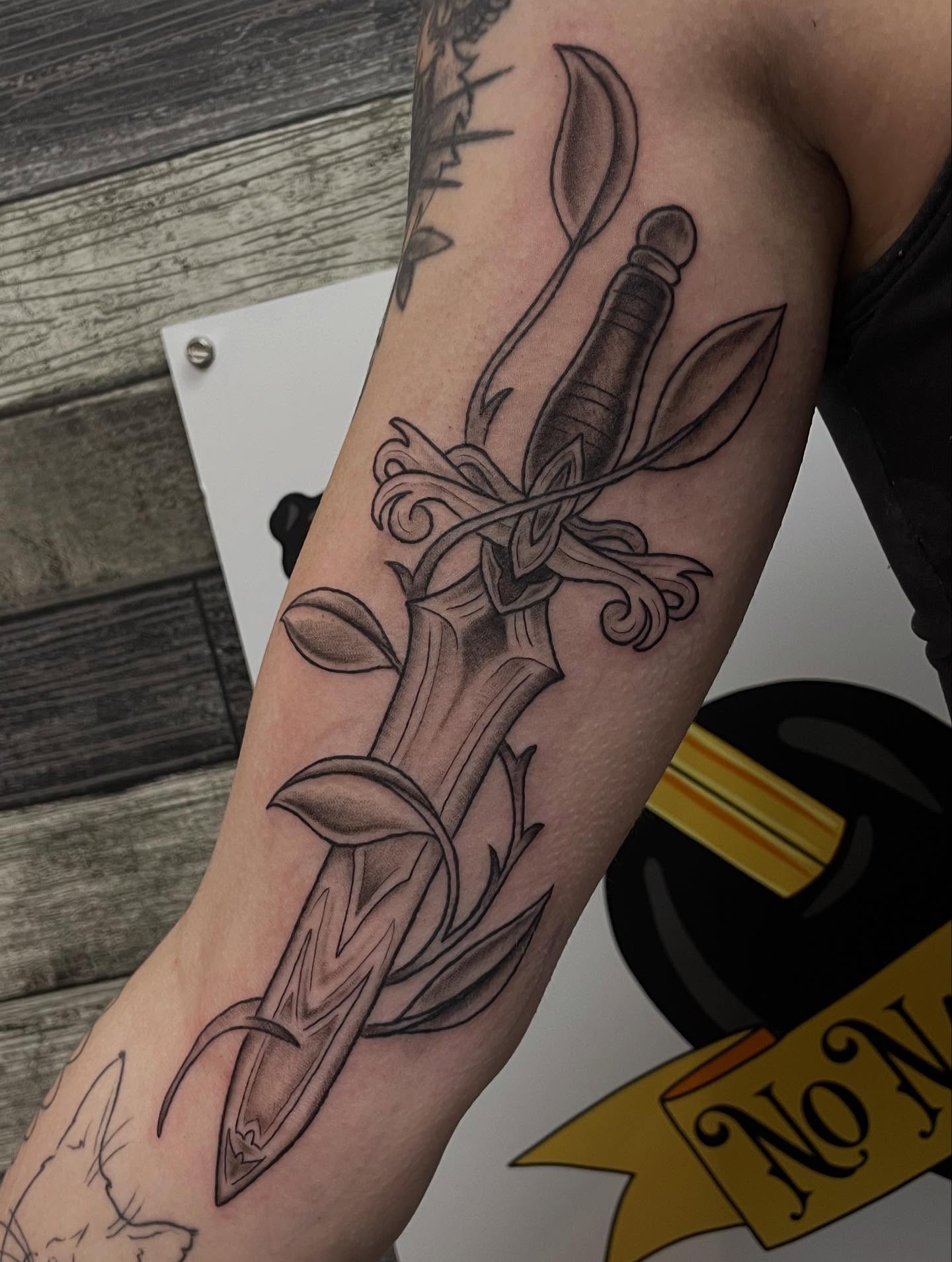 Sword and leaves realism tattoo on the forearm by Stevie Timmreck, Utica, Michigan