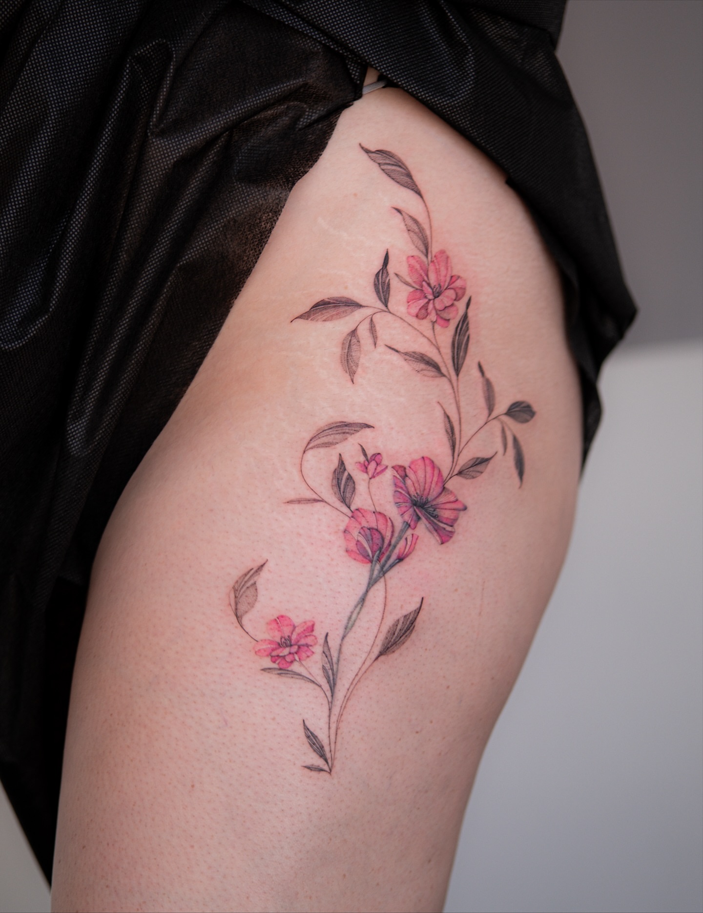 Floral arrangement watercolor tattoo on the thigh by Flower Tattoo Sf