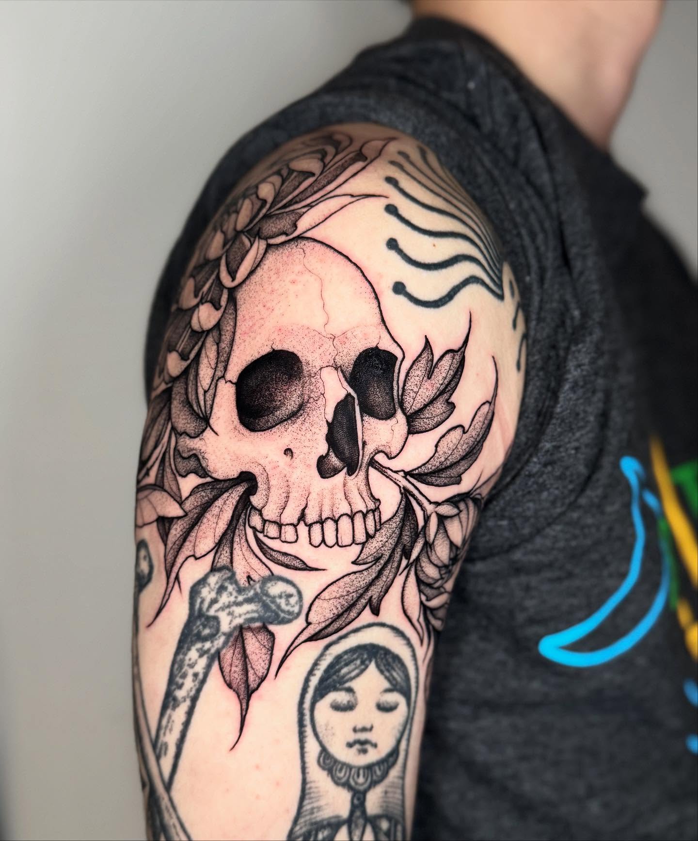 Skull and floral realism tattoo on the shoulder by Lauren Llerandi