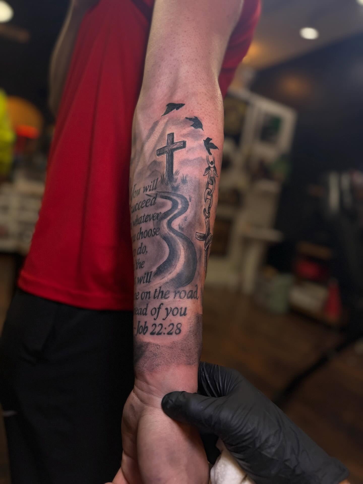 Cross and snake black and grey tattoo on the forearm by Robbie Roberson