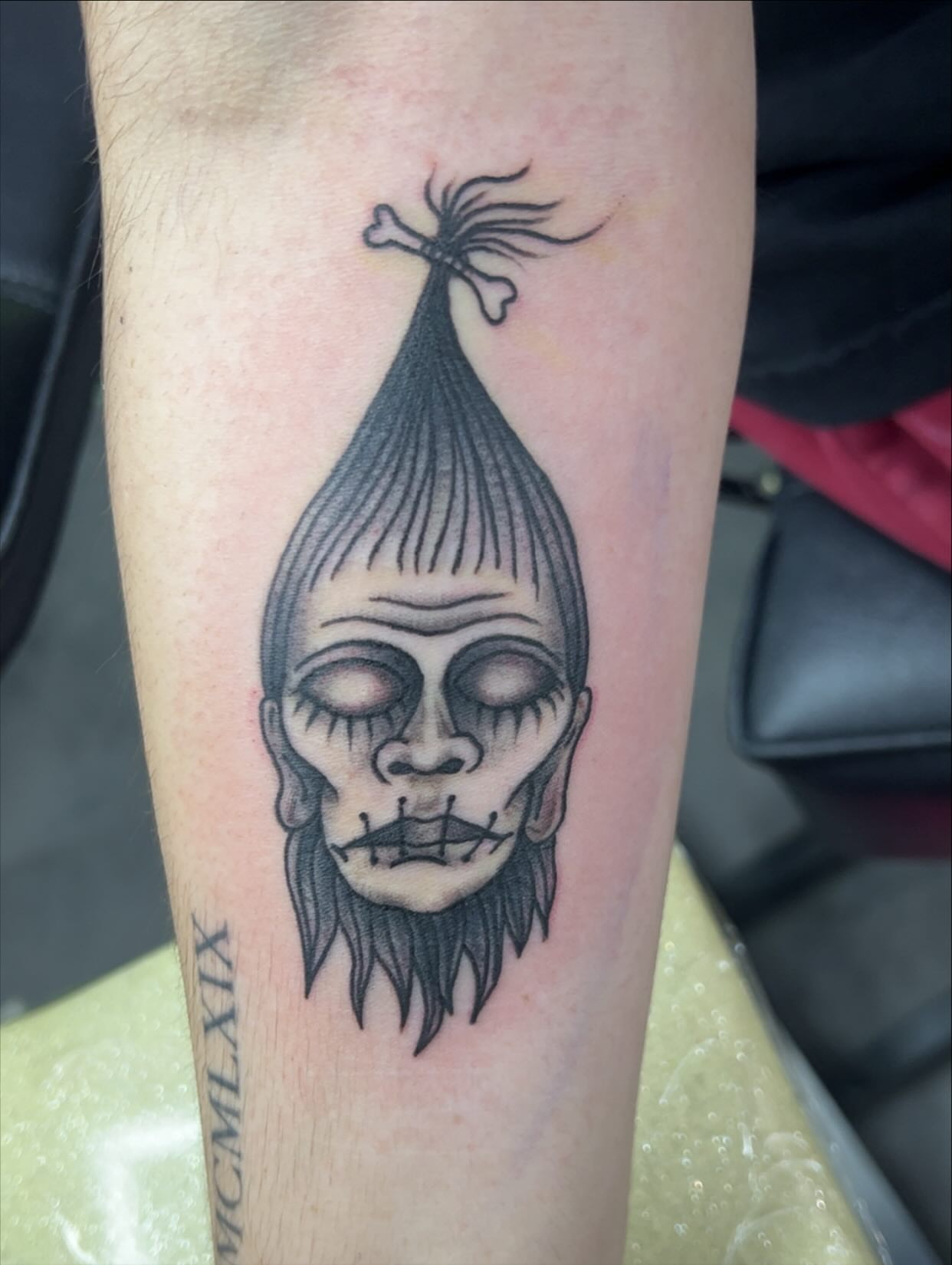 Skull with hair black and grey tattoo on the forearm by Sav