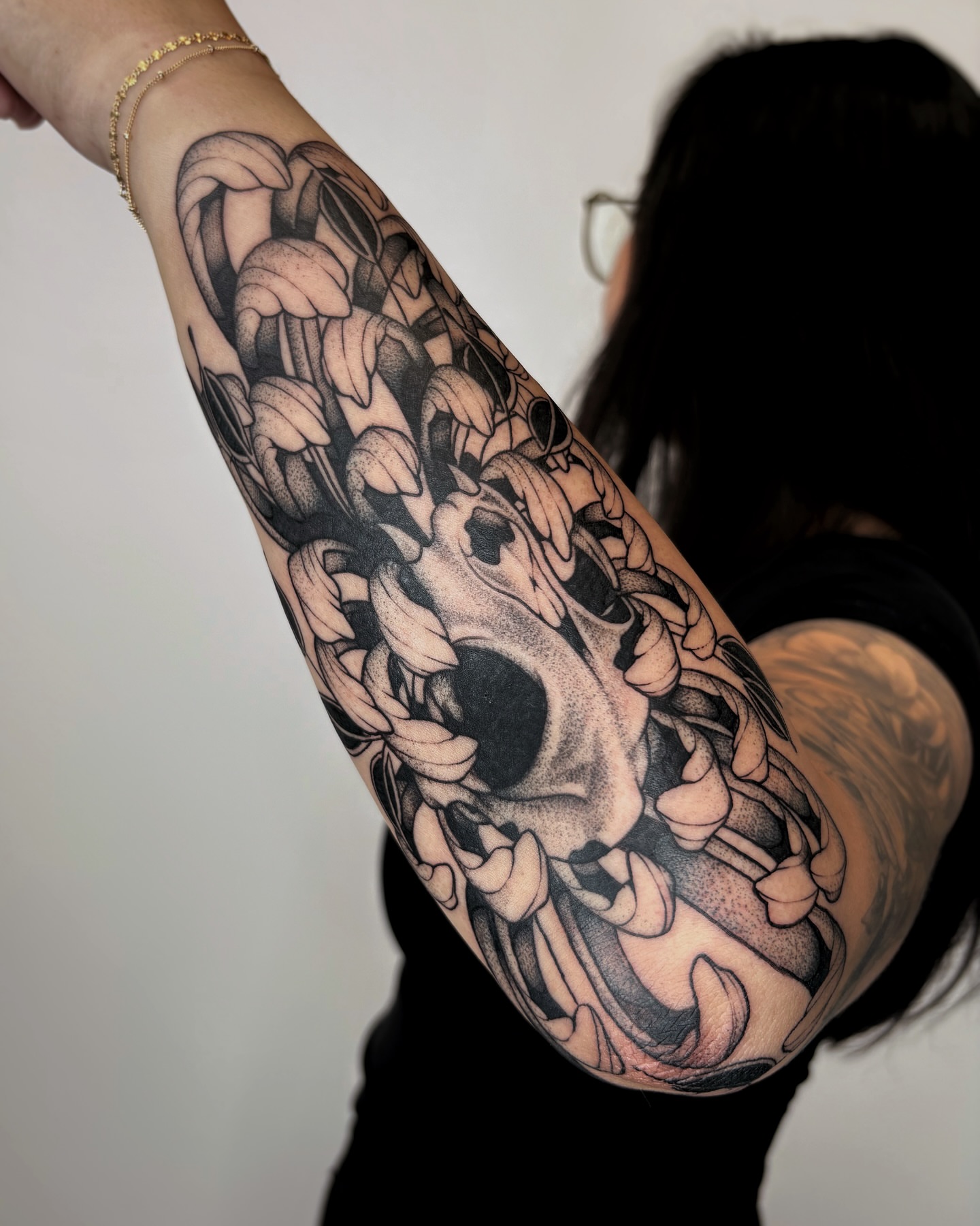 Skull and flowers realism tattoo on the forearm by Kuya, Berkeley, California