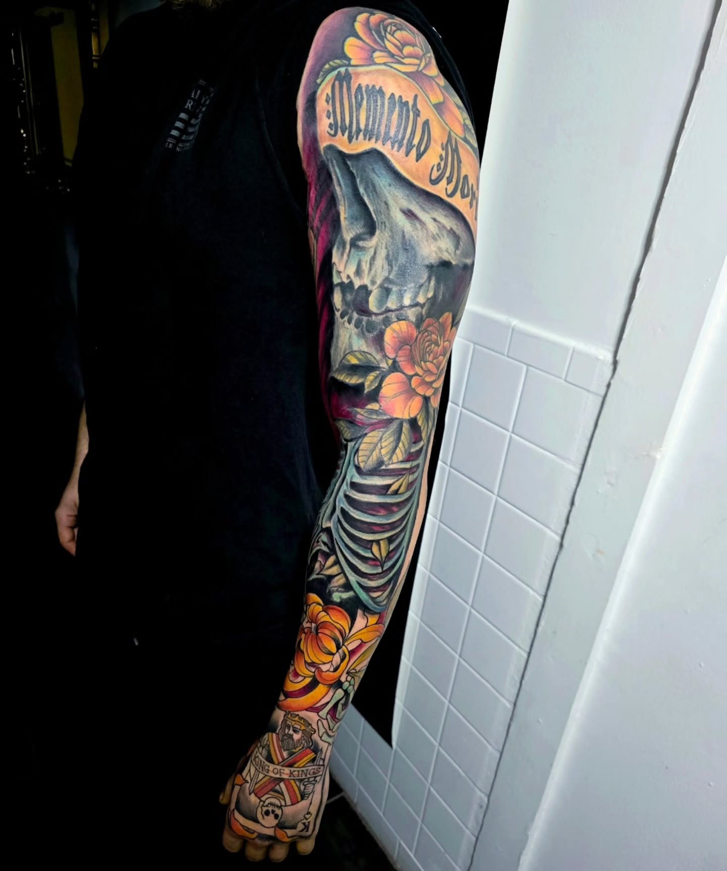 Skeleton with roses American traditional tattoo on the upper arm by Michael Latendresse