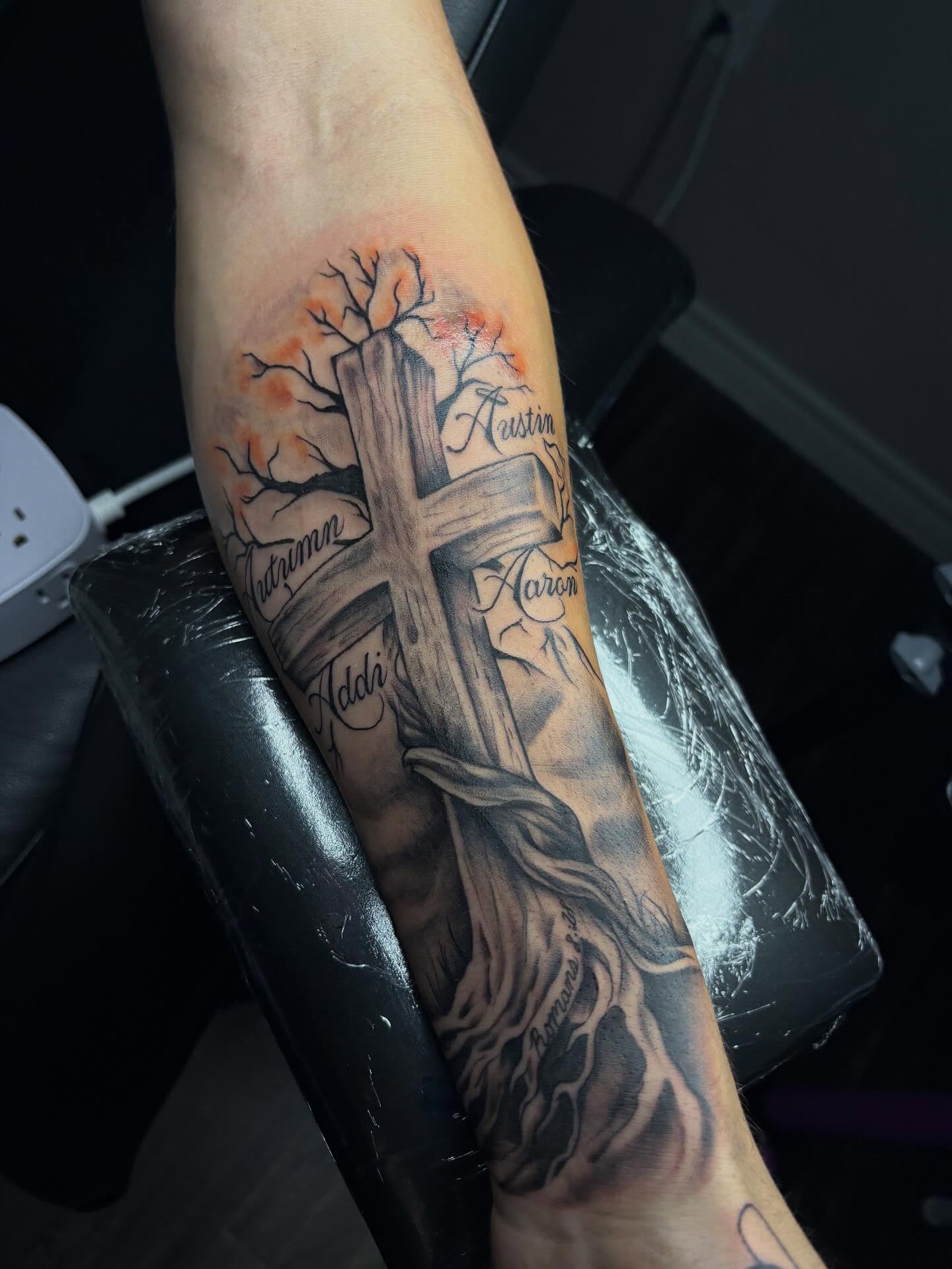 Cross with tree and names black and grey tattoo on the forearm by ✧ Dallas Tattoo Artist  ✧