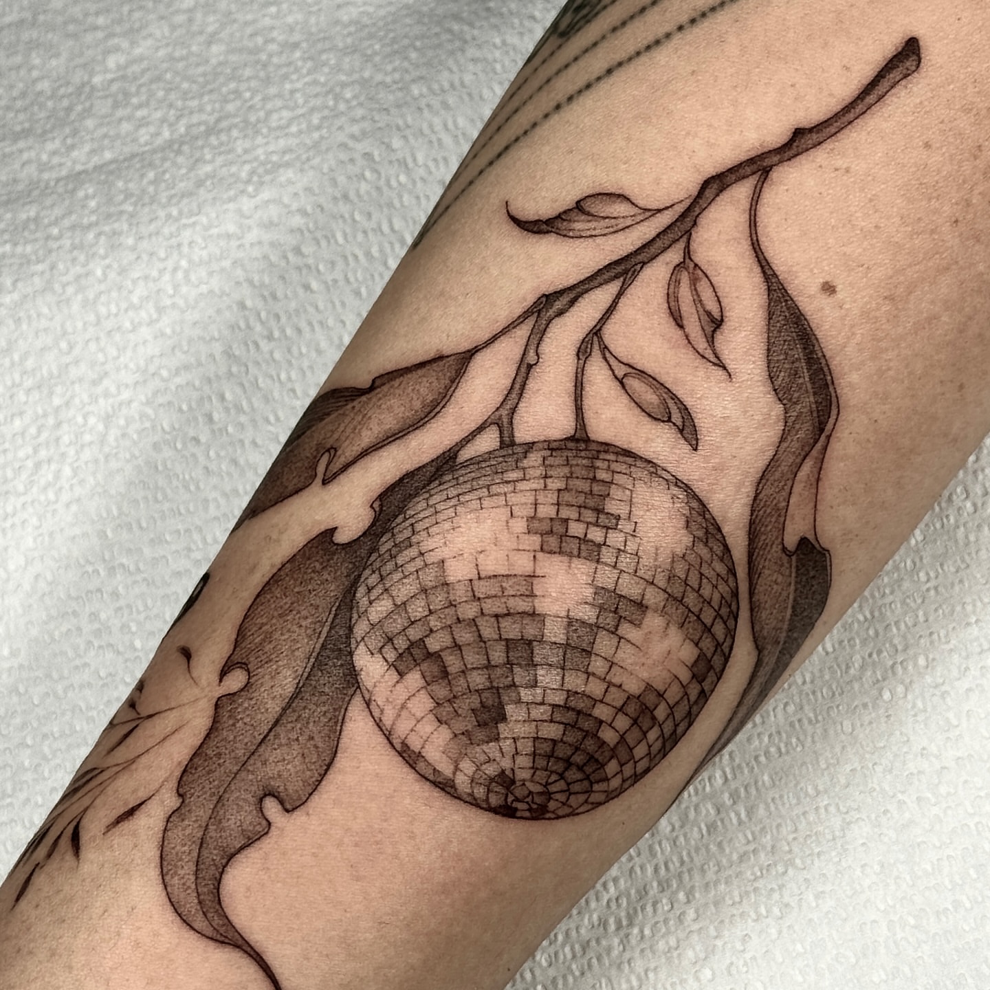 Mirror ball dotwork tattoo on the forearm by Molly Murray