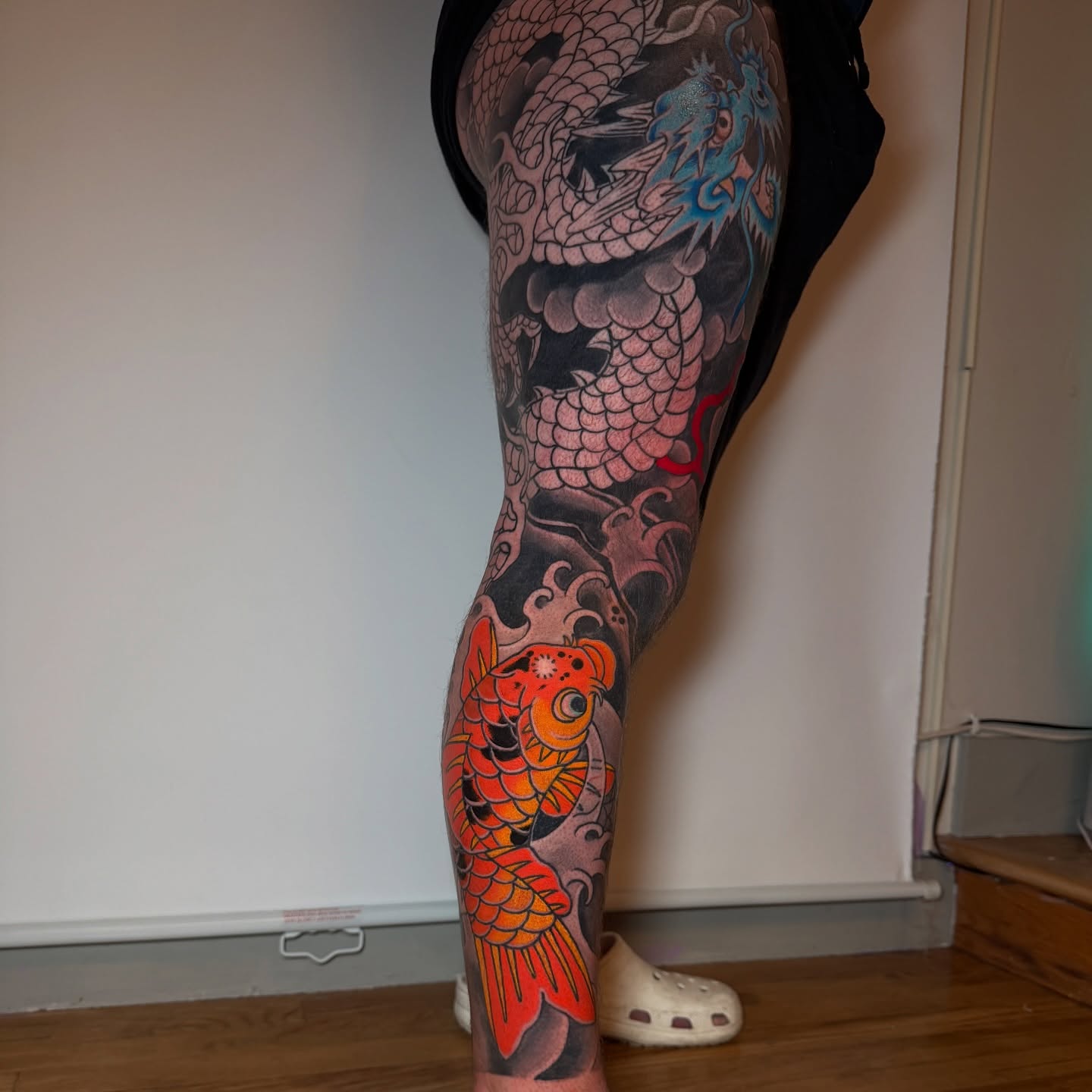 Dragon and koi fish American traditional tattoo on the leg by Tattoo Artist Los Angeles