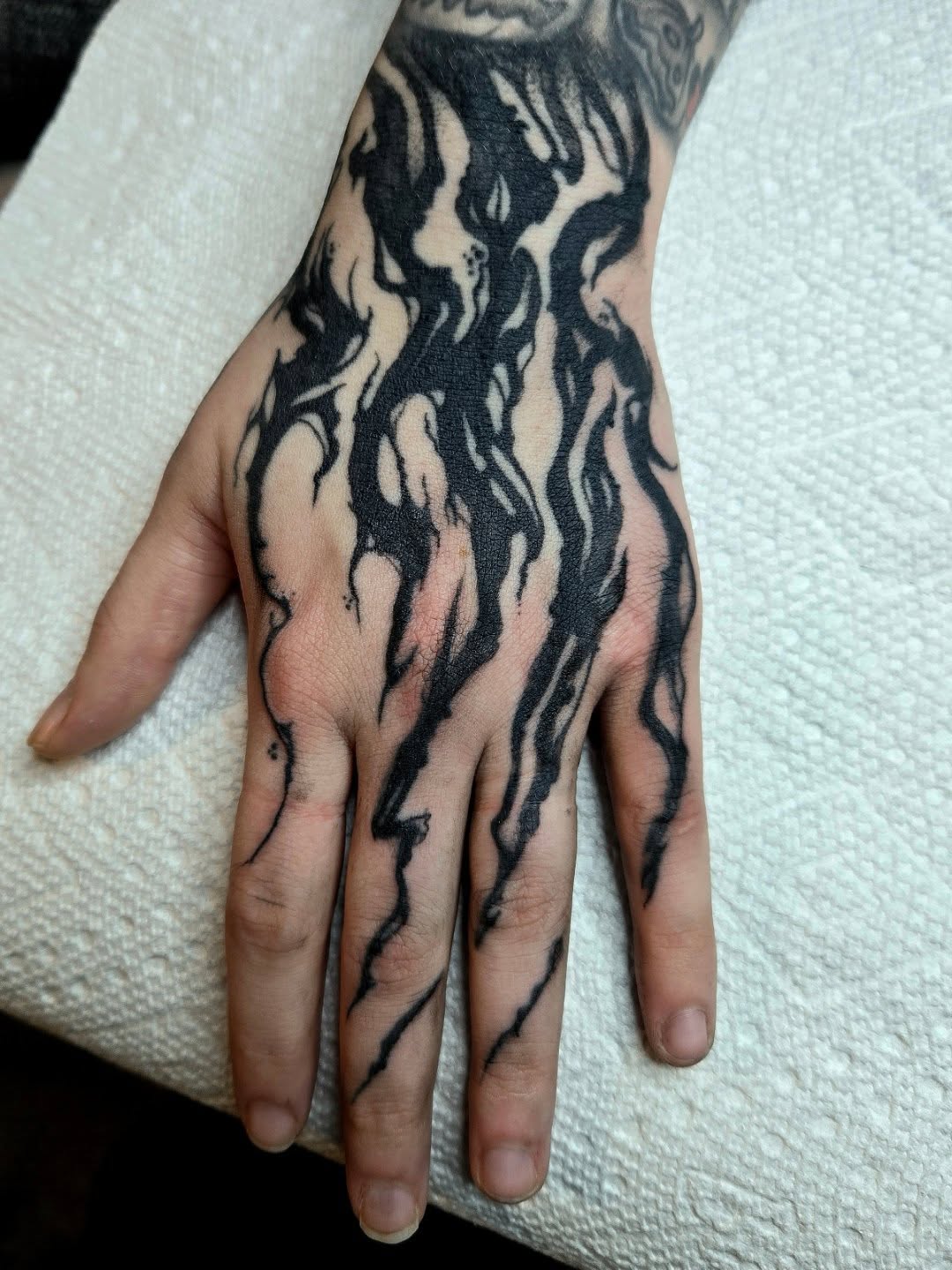 Flame black and grey tattoo on the hand by Amanda Hinrichs