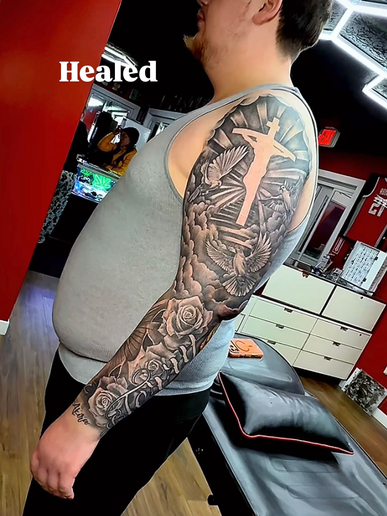 Religious figure with dove black and grey tattoo on the upper arm by Tatt2T (T King)