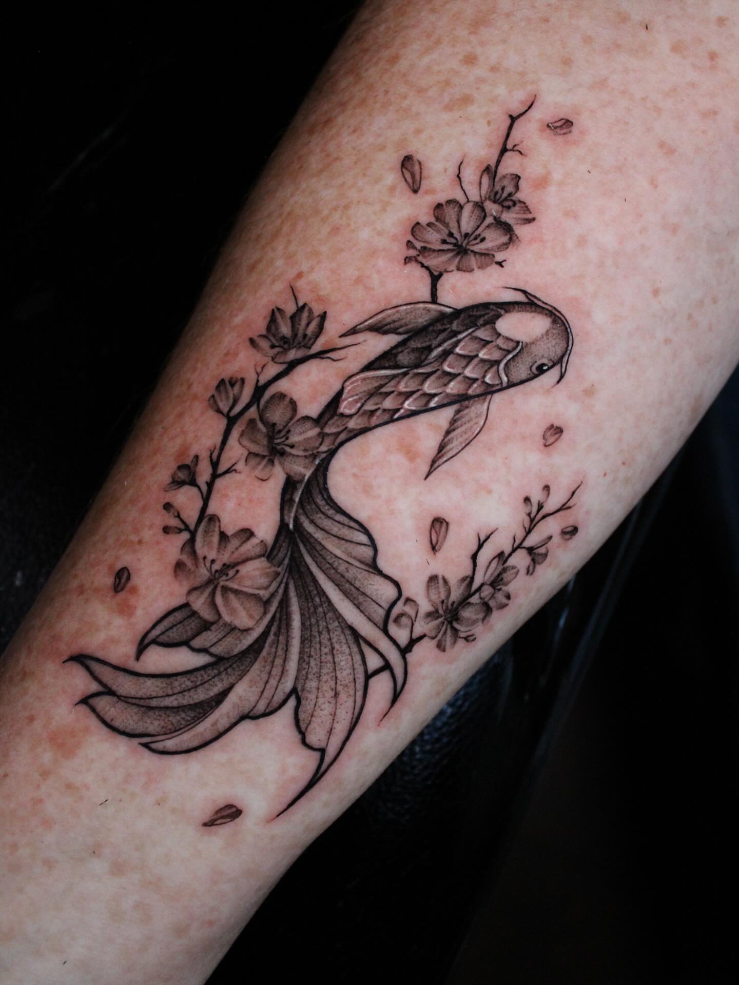 Koi fish and blossoms black and grey tattoo on the forearm by 𝕵𝖎𝖒𝖎 𝕯𝖊𝕽𝖔𝖘𝖆🥀, Everett, Washington
