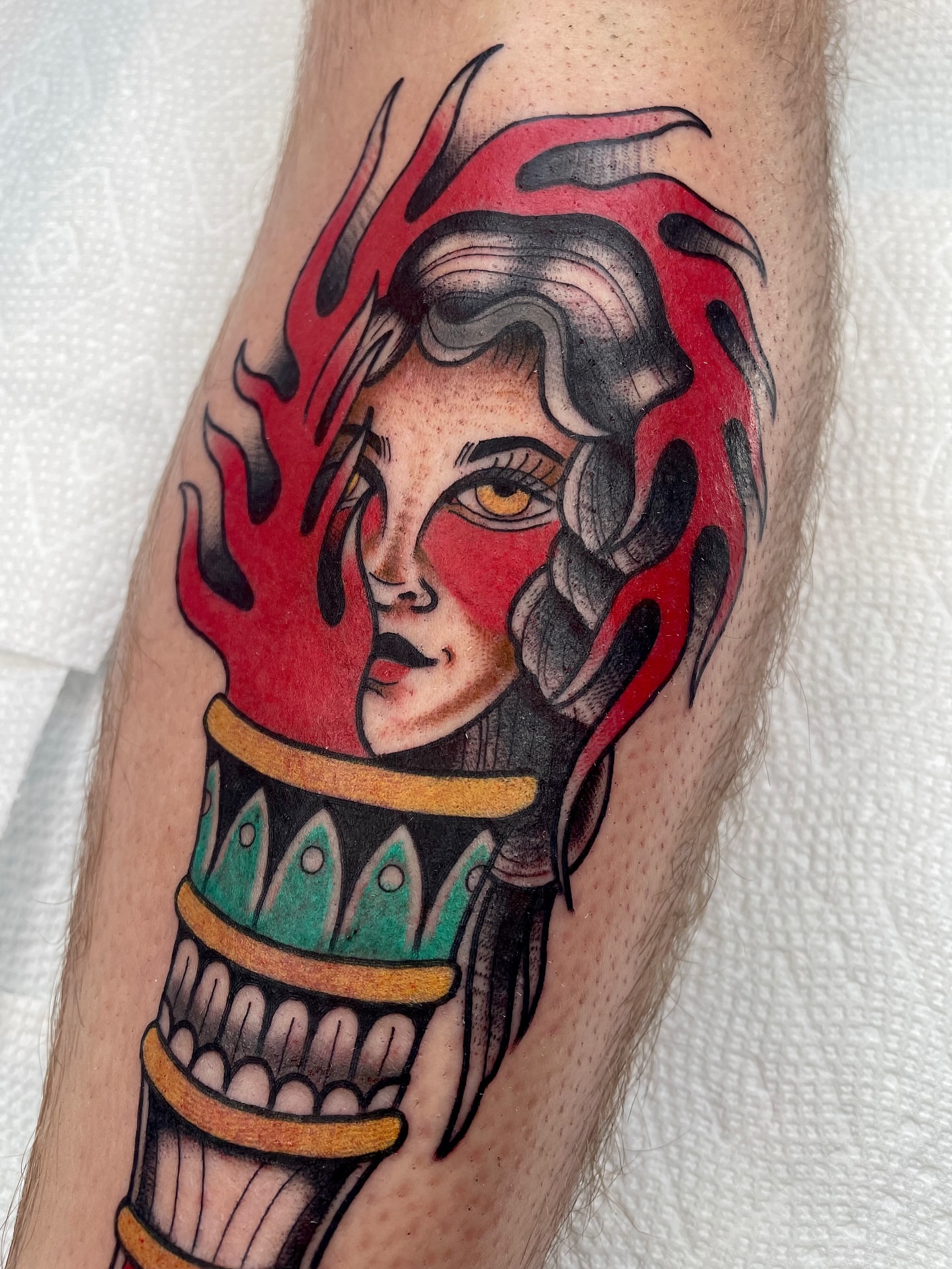 Flame-wrapped woman American traditional tattoo on the forearm by Josh Johns